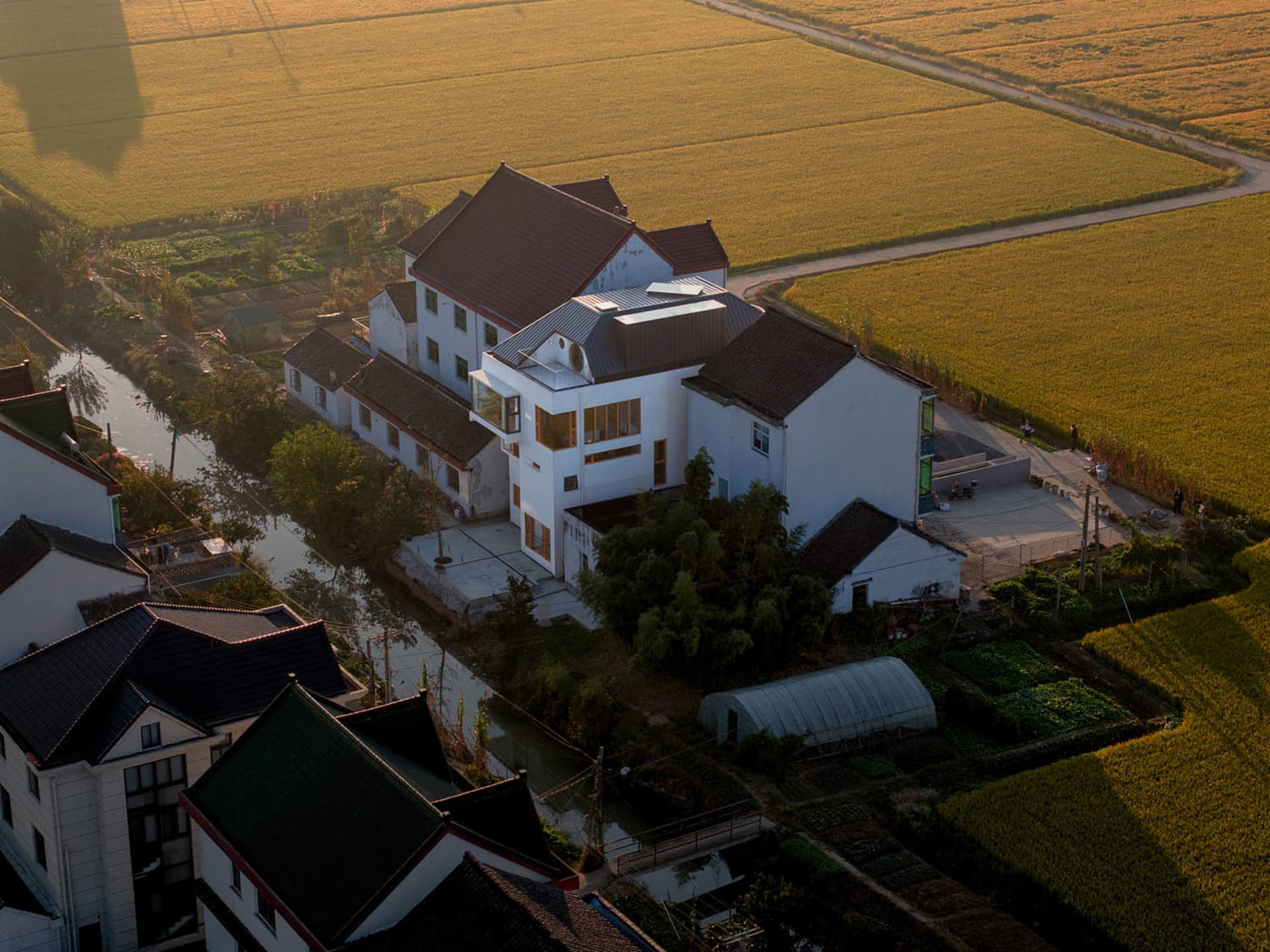 現代住宅擁有白色粉刷牆面，周圍環繞田野。