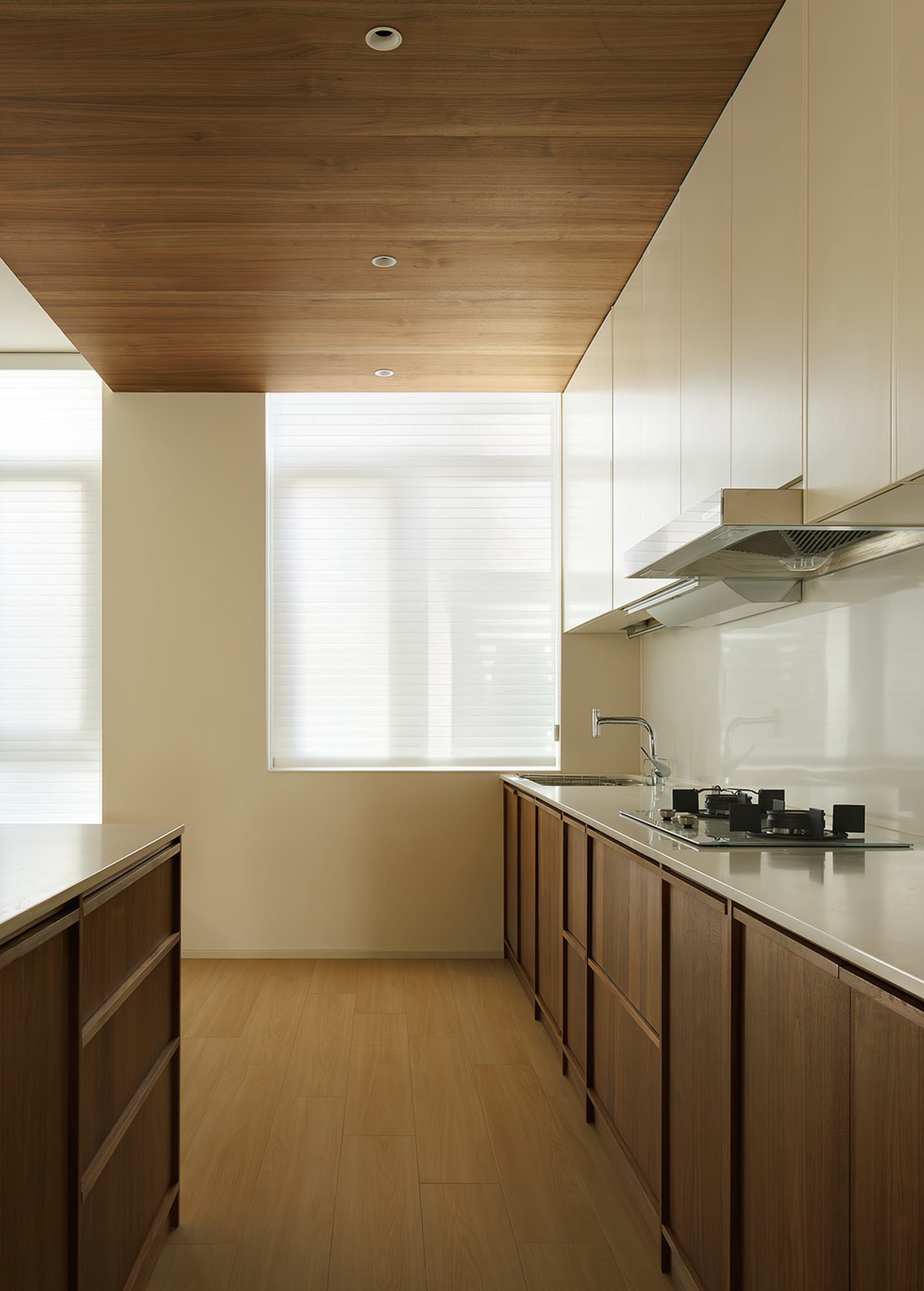 Modern residential kitchen featuring wooden cabinets and a glass backsplash.