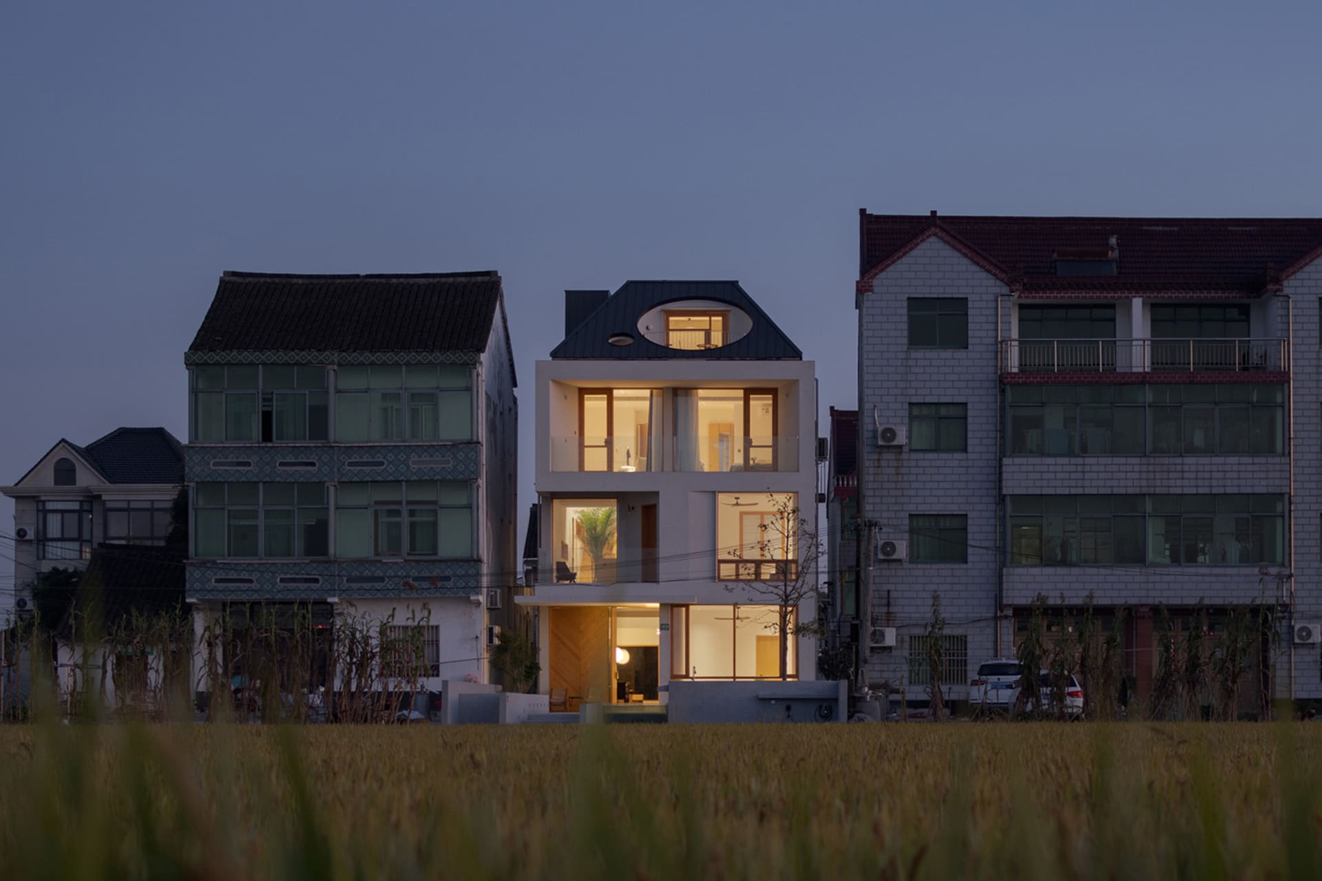 A modern residential house with large glass windows and doors.