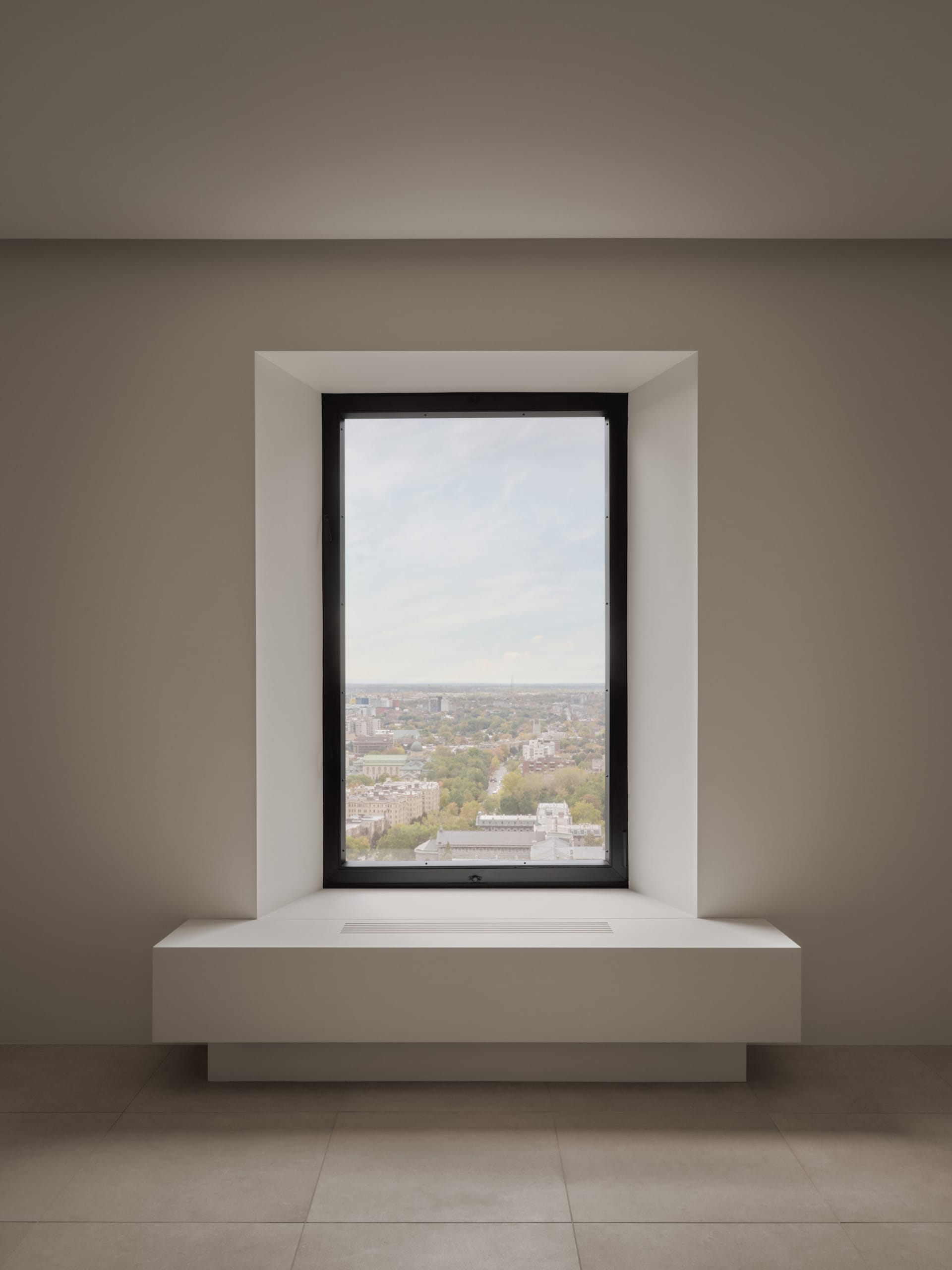 Modern window overlooking a cityscape with a metal frame.