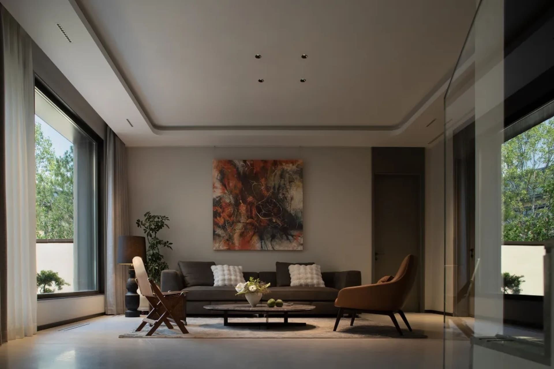 Modern living room with a contemporary sofa, chairs, and abstract art on the wall.