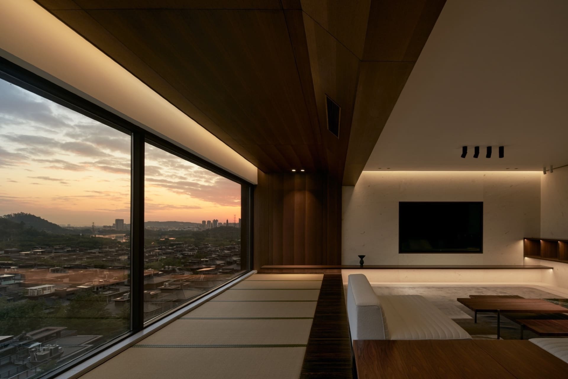 Modern living room featuring tatami mats on wooden floor and contemporary furniture.