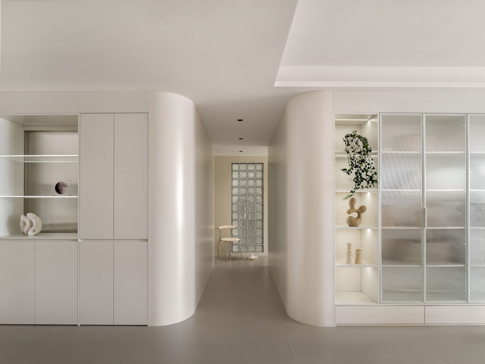 A minimalist interior featuring concrete and glass materials.