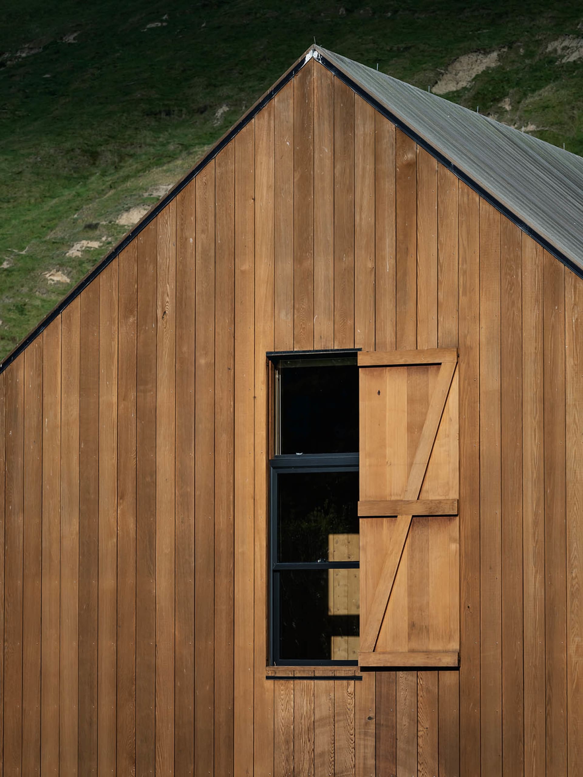 A wooden shed with a window and a wooden shutter.