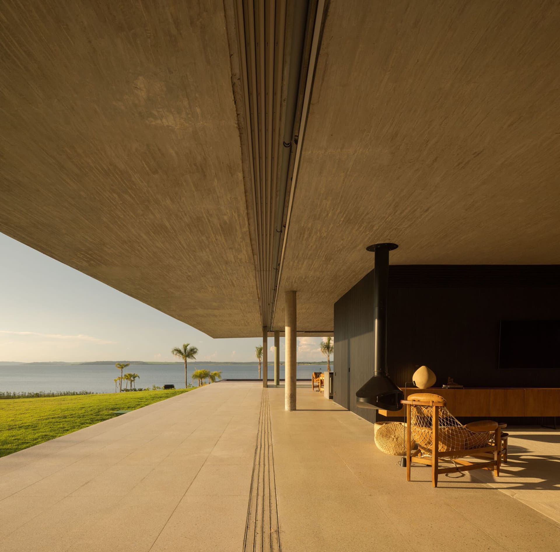 Modern residential living room featuring concrete flooring with a view of water.