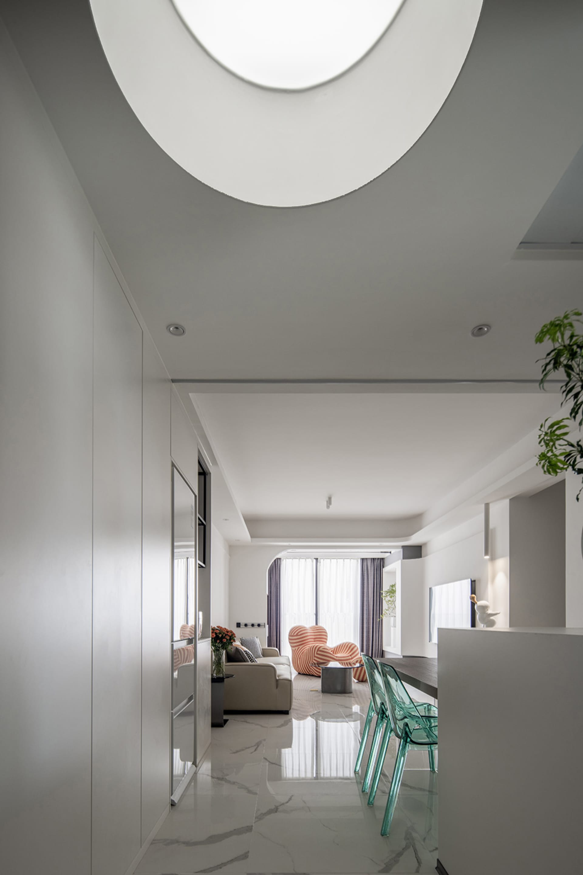 A modern living room featuring marble flooring and minimalist decor.