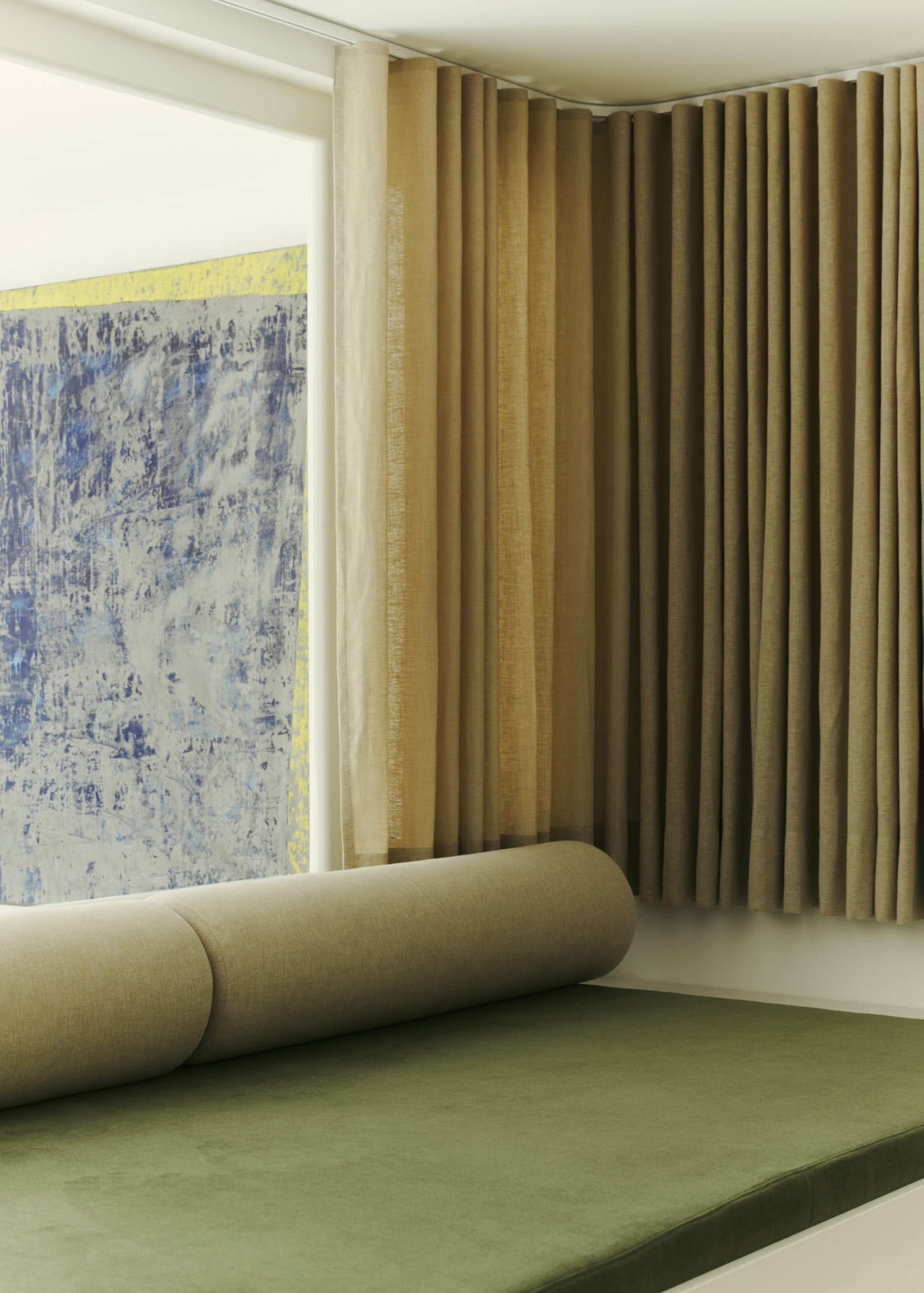 Modern bedroom with textured cushions, soft throw, and blinds