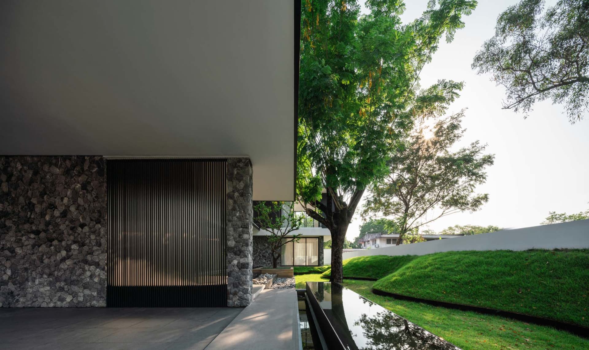 A modern residential facade featuring glass and stone materials.