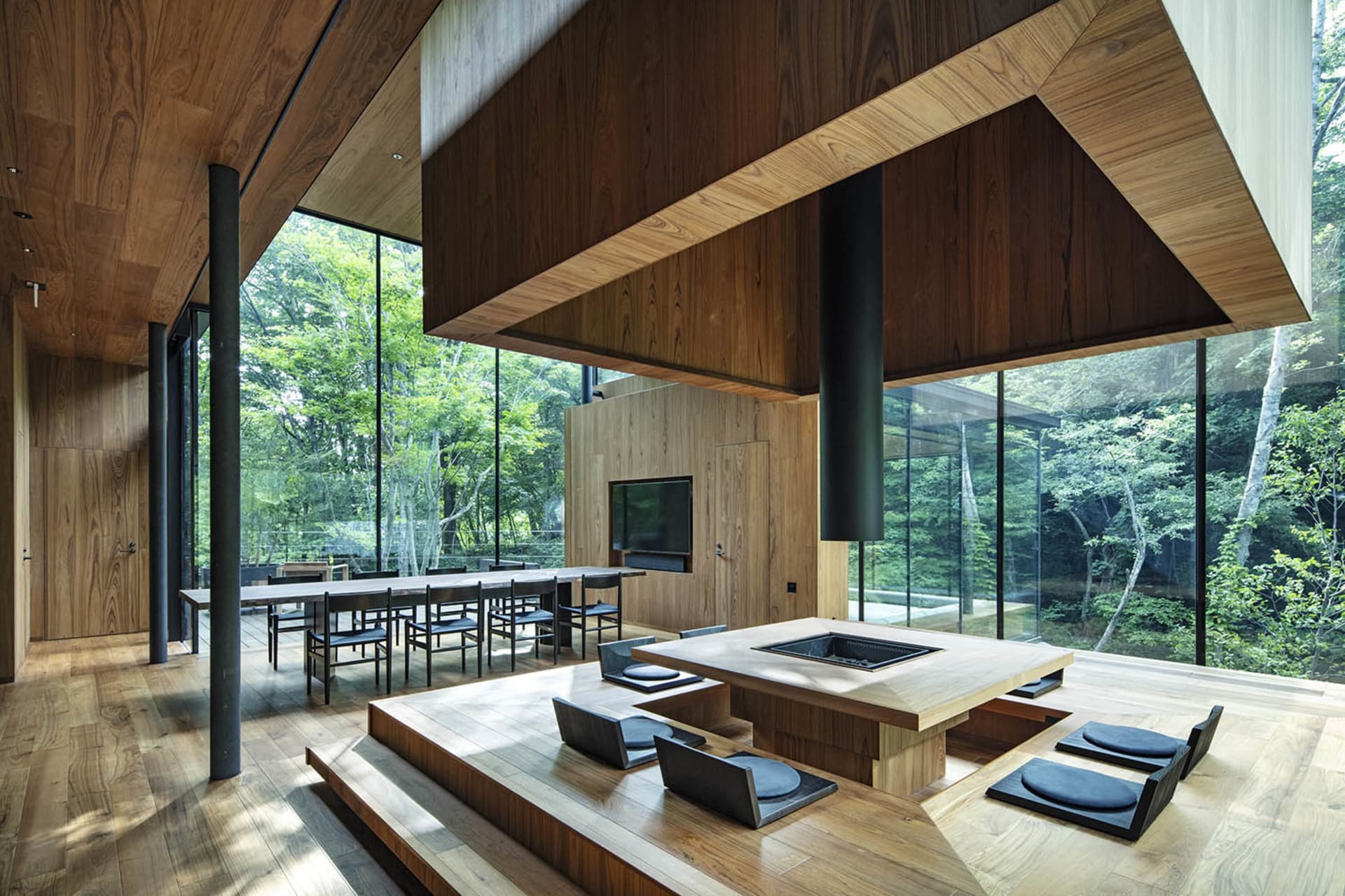 A modern living room with wooden furniture and a central fireplace.