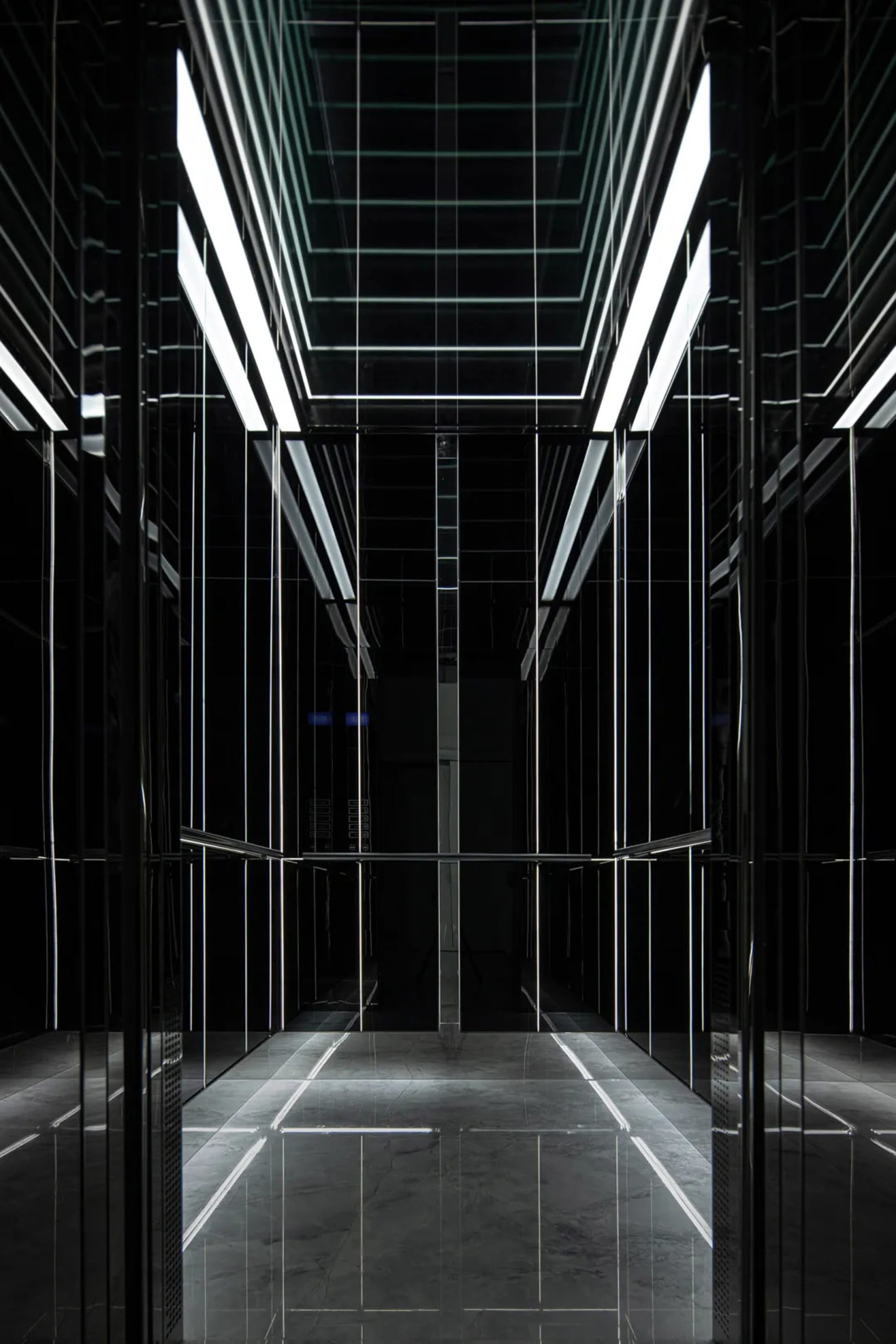 An empty minimalist lobby with black steel walls and floor.