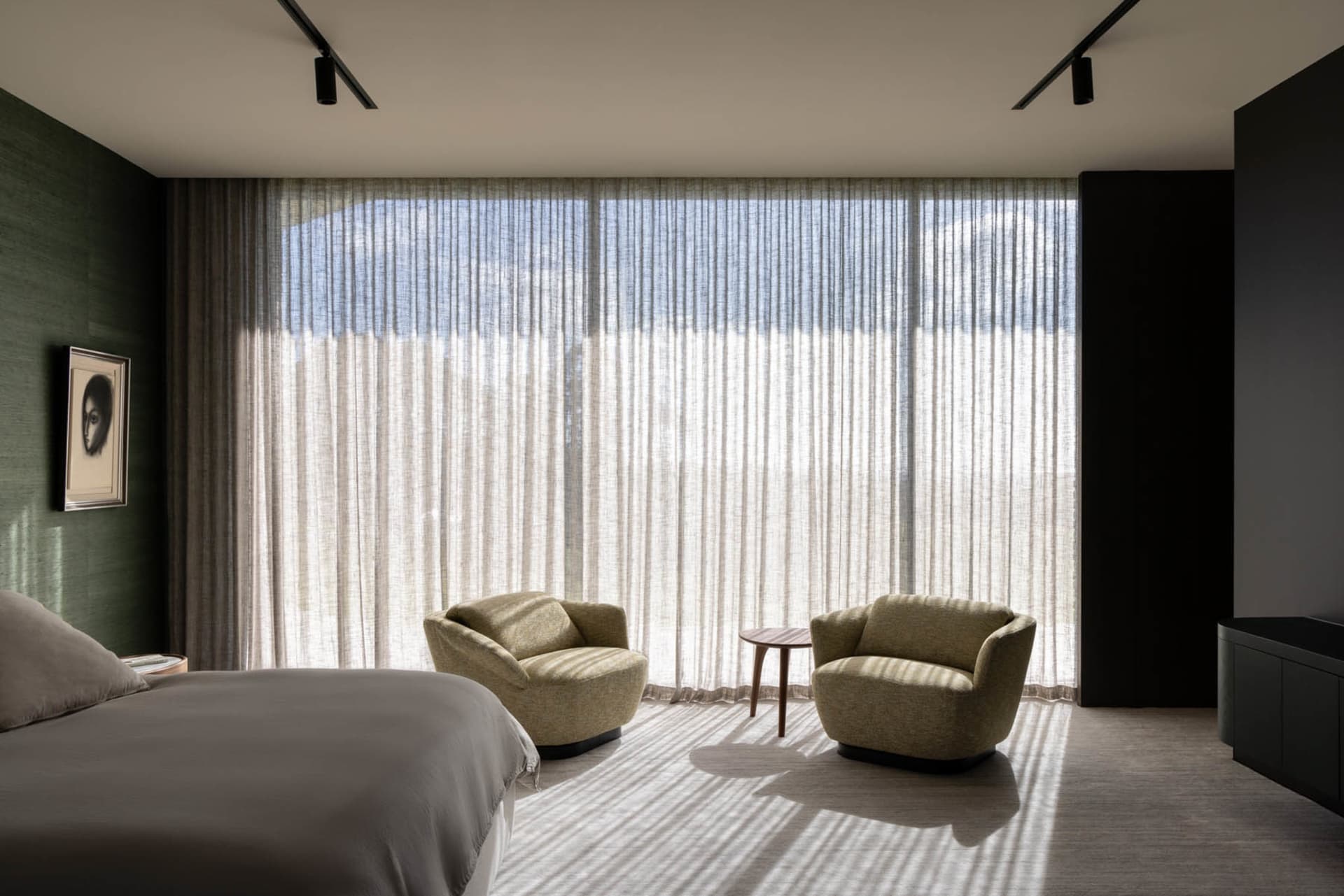 Modern bedroom featuring fabric furniture and glass windows.