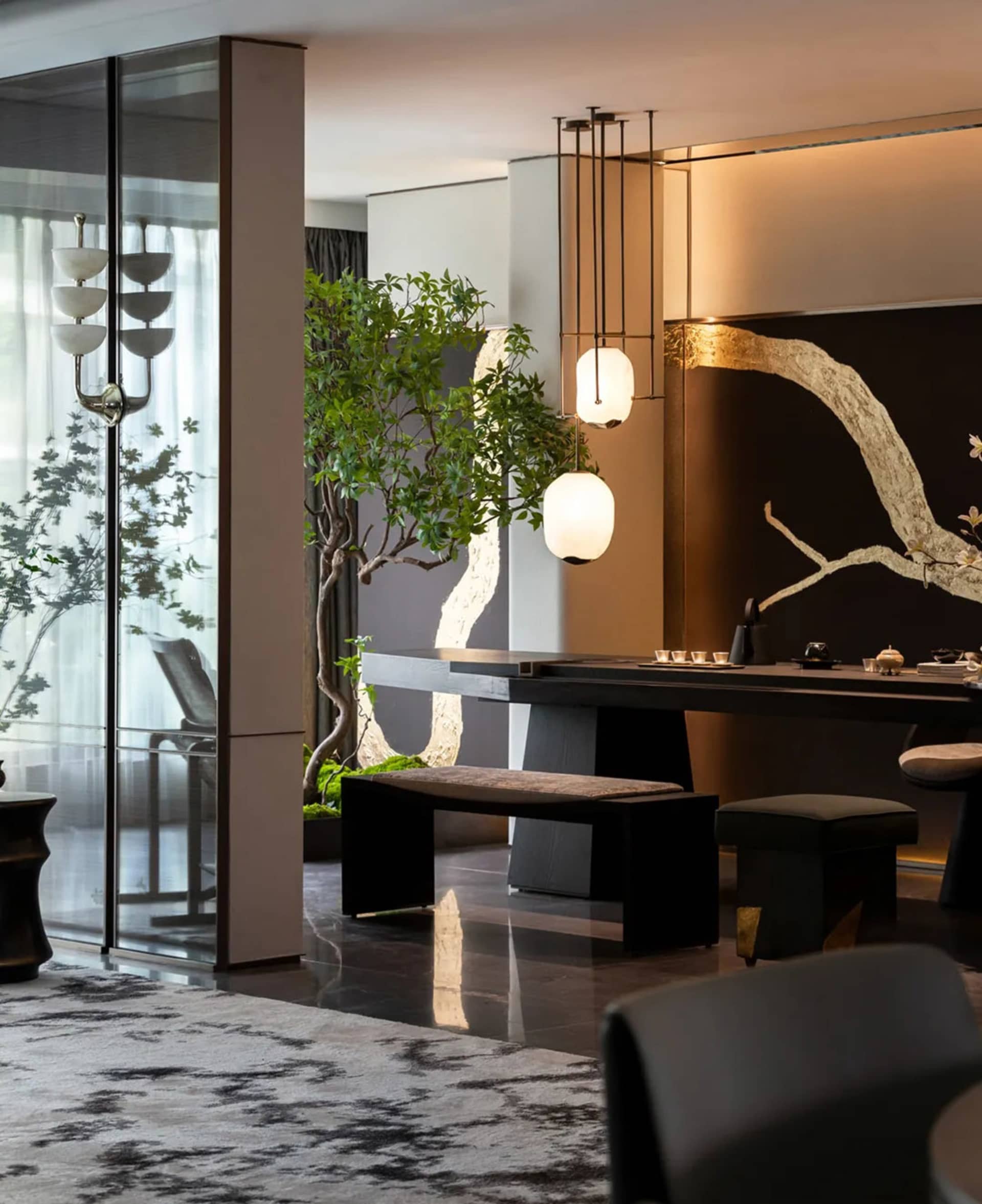 A modern living room featuring wooden furniture, glass windows, and metal accents.