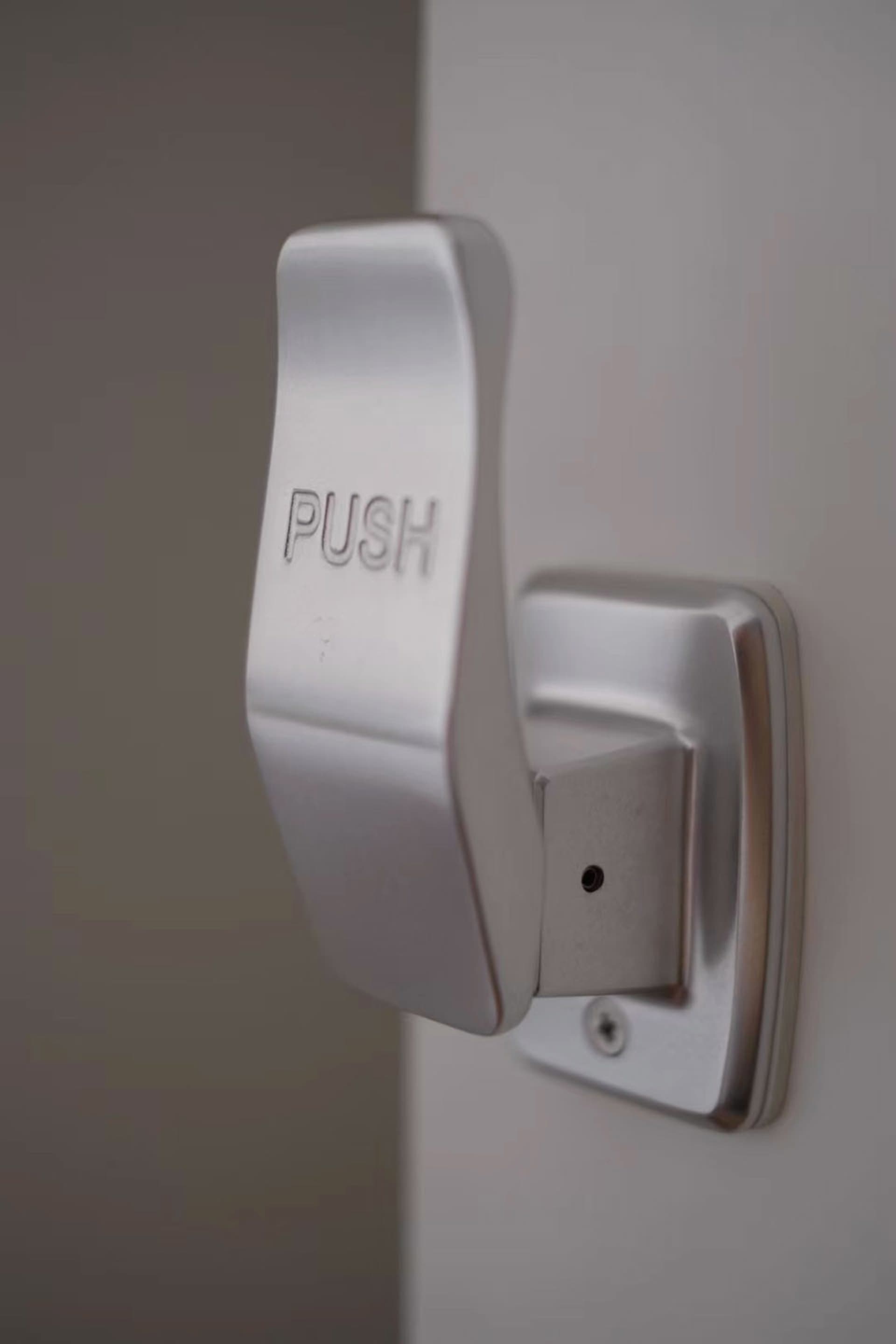 銀色金屬按壓式把手，上面刻有「PUSH」字樣