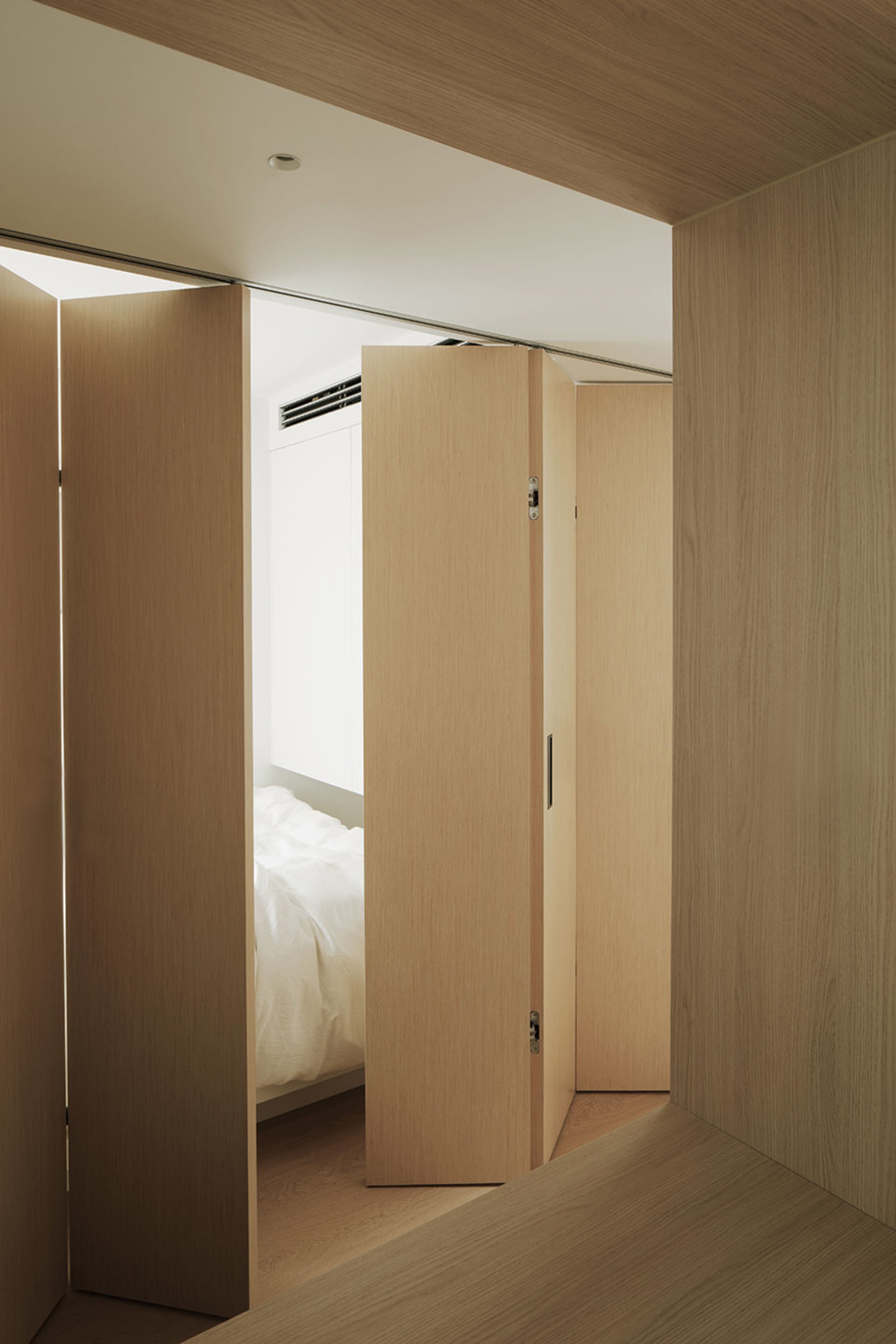 A minimalist bedroom with a wooden platform bed