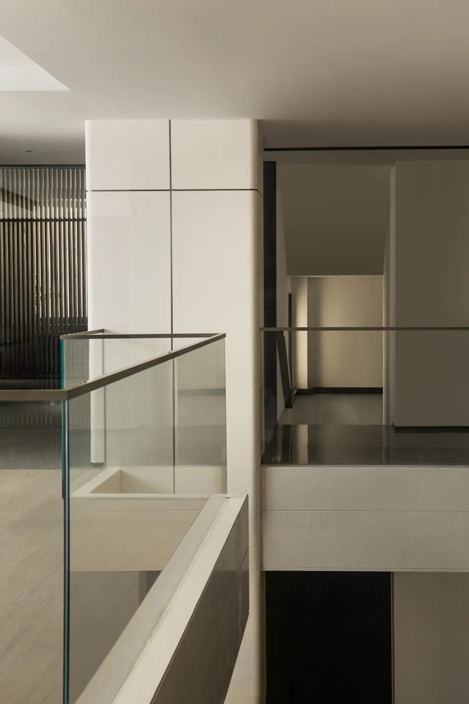 Modern interior with glass walls and stairs in a minimalist design.