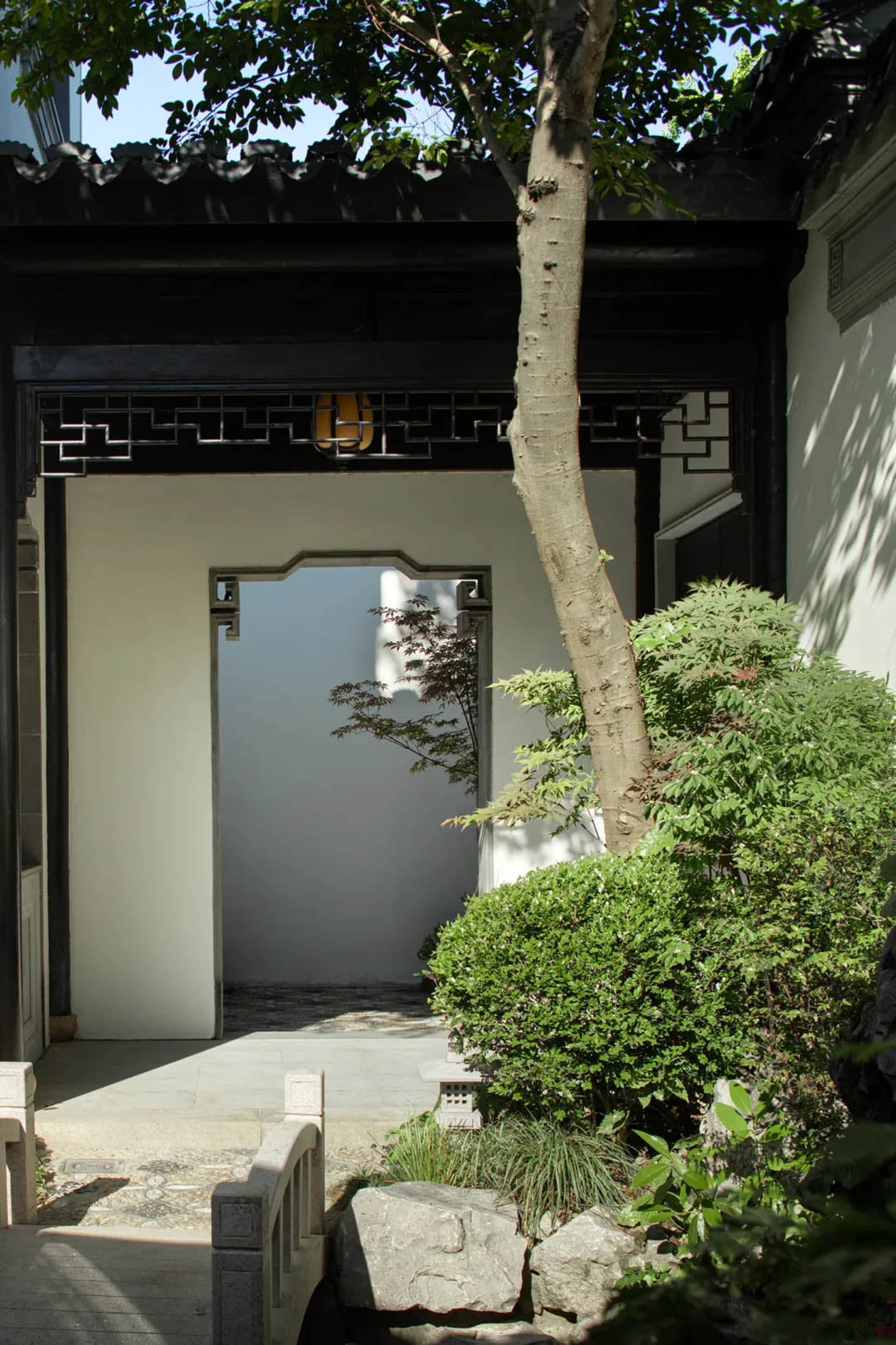 A traditional Chinese garden featuring stone pathways and wooden elements.