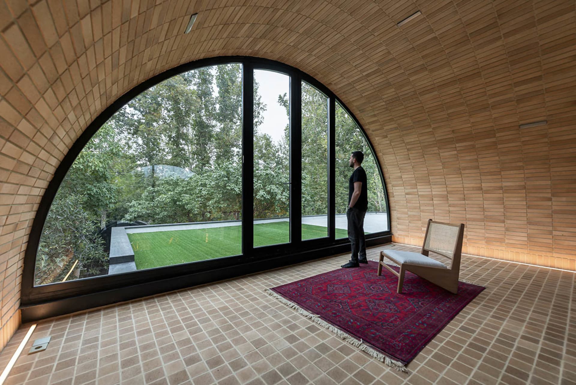 A modern living room with a large arched brick window.