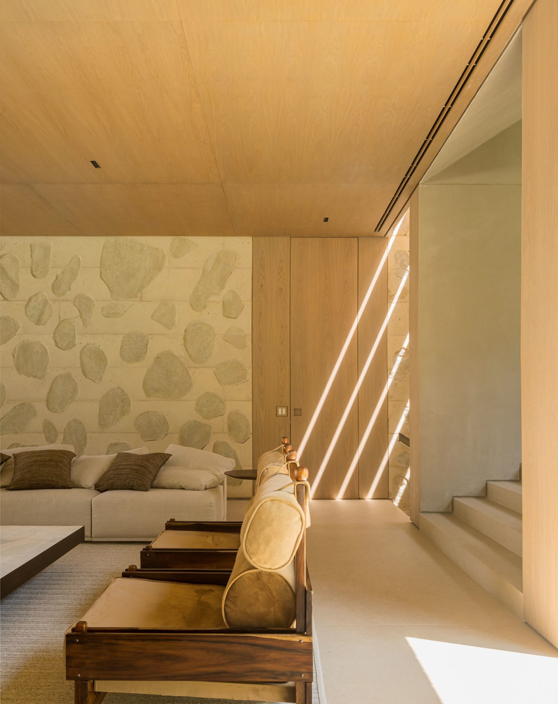 A minimalist living room with concrete and wooden elements.