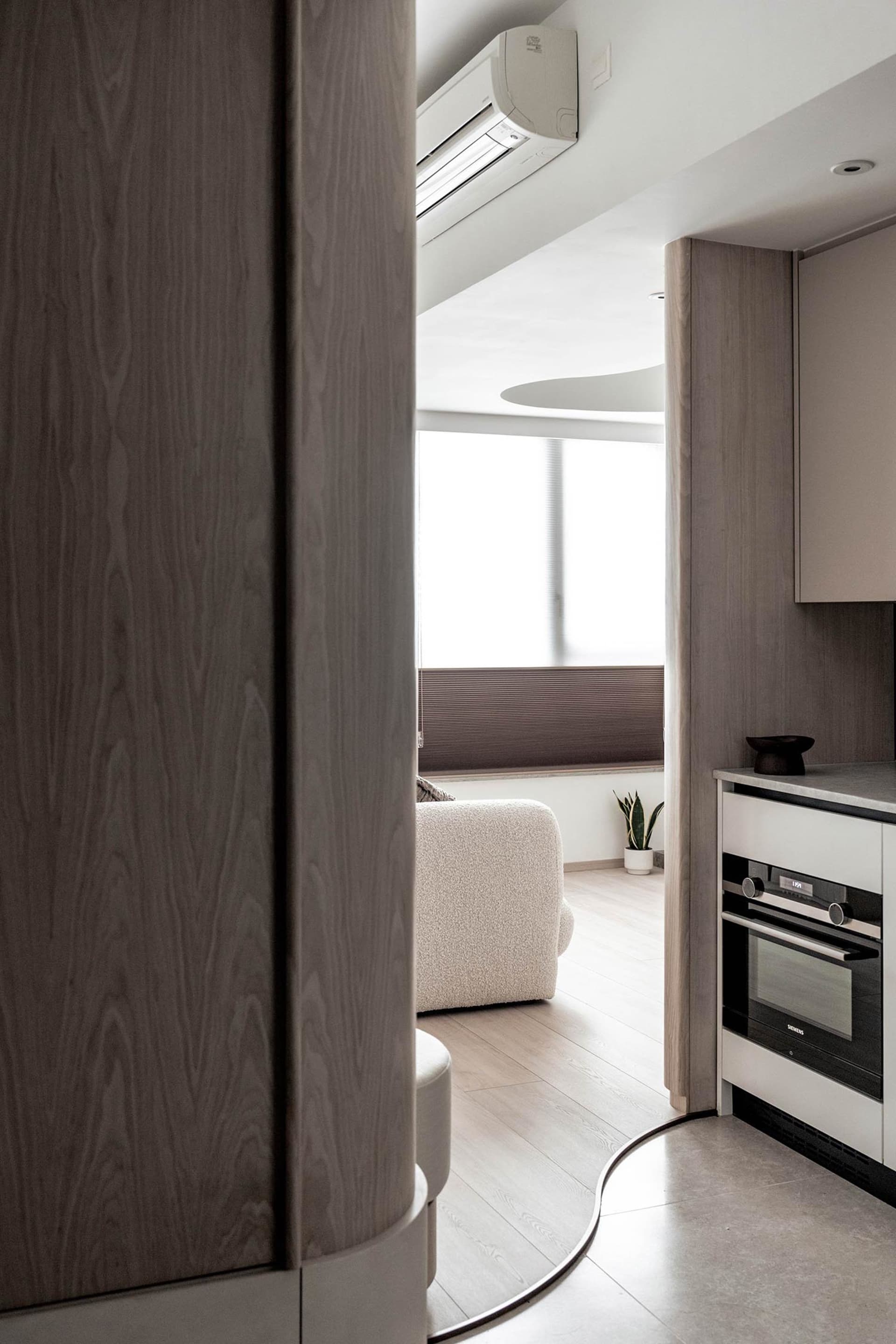 Modern minimalist kitchen featuring sleek, contemporary wood finishes and a clean, uncluttered design.