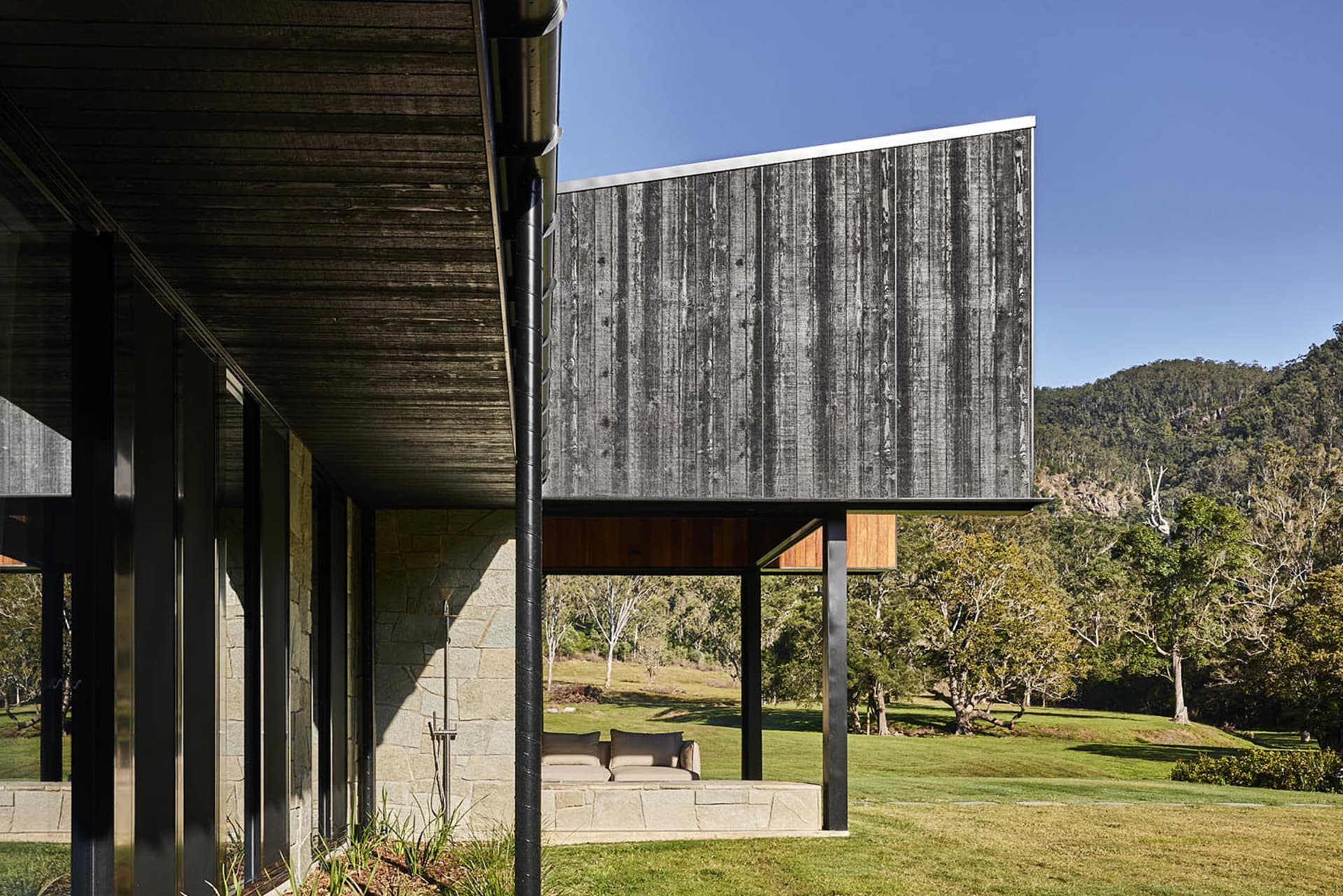 現代住宅外觀，石材基座搭配玻璃面板。