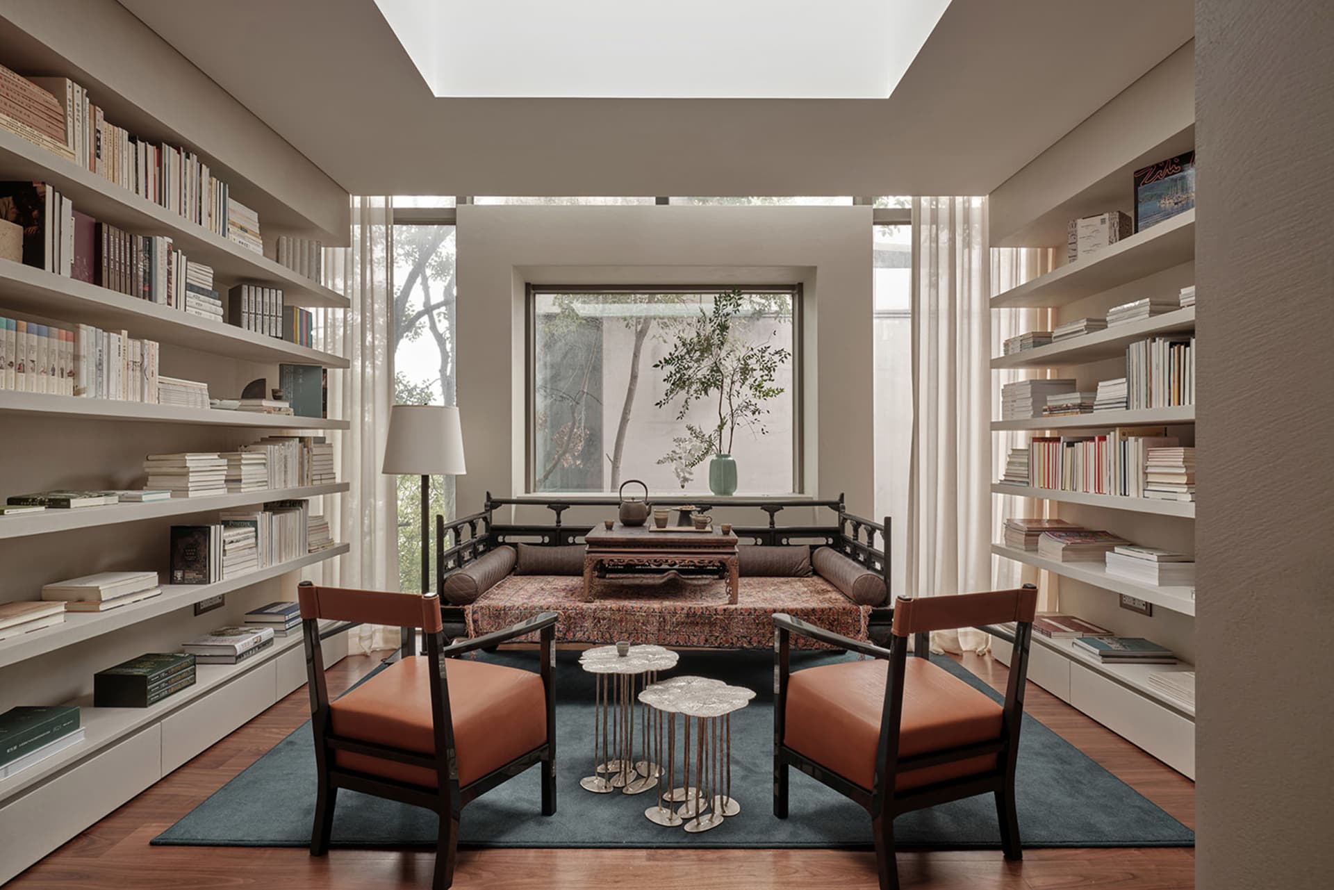 A modern living room with bookshelves, comfortable seating, and a cozy atmosphere.