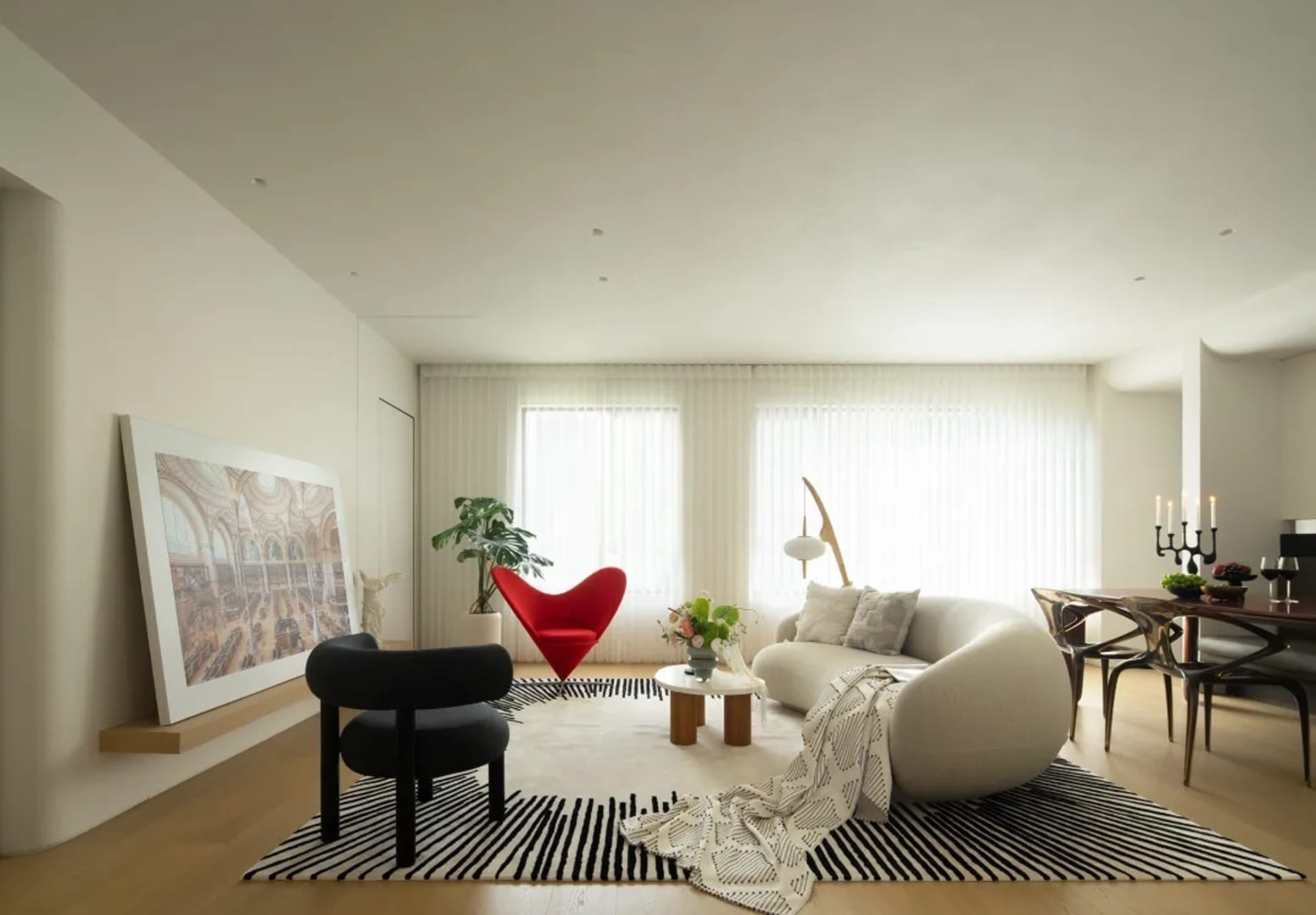 Modern living room with minimalist interior design, featuring neutral-colored furniture and decor, and a subtle black and whi