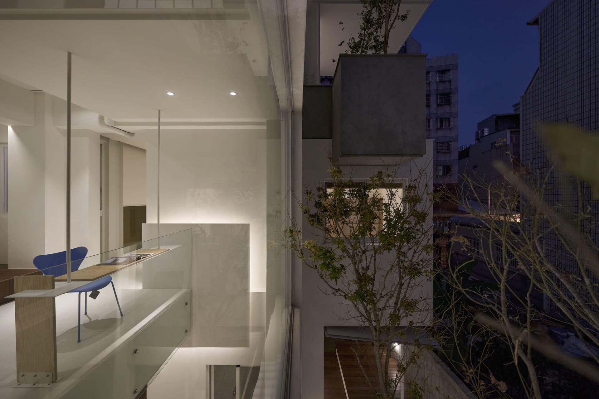 Modern residential interior features glass walls and light-filled spaces.
