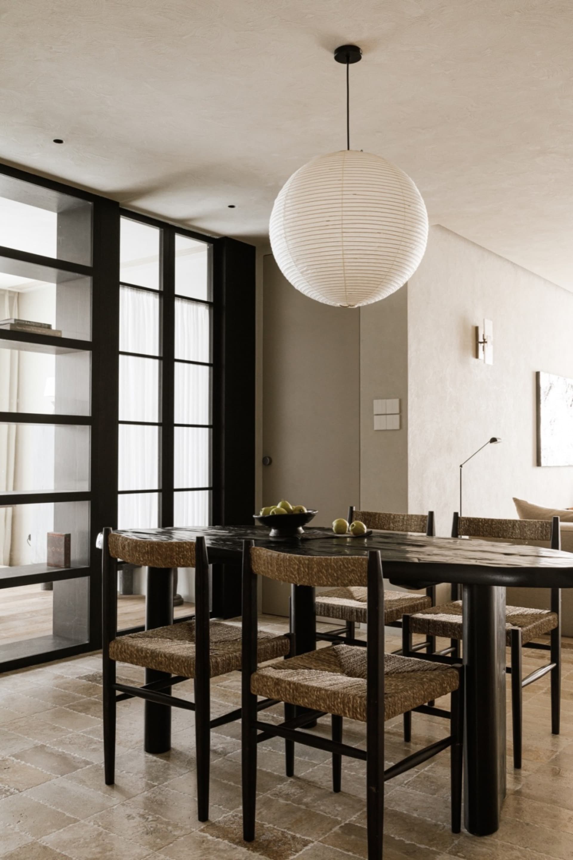 Modern dining room with wooden furniture and a round light fixture.