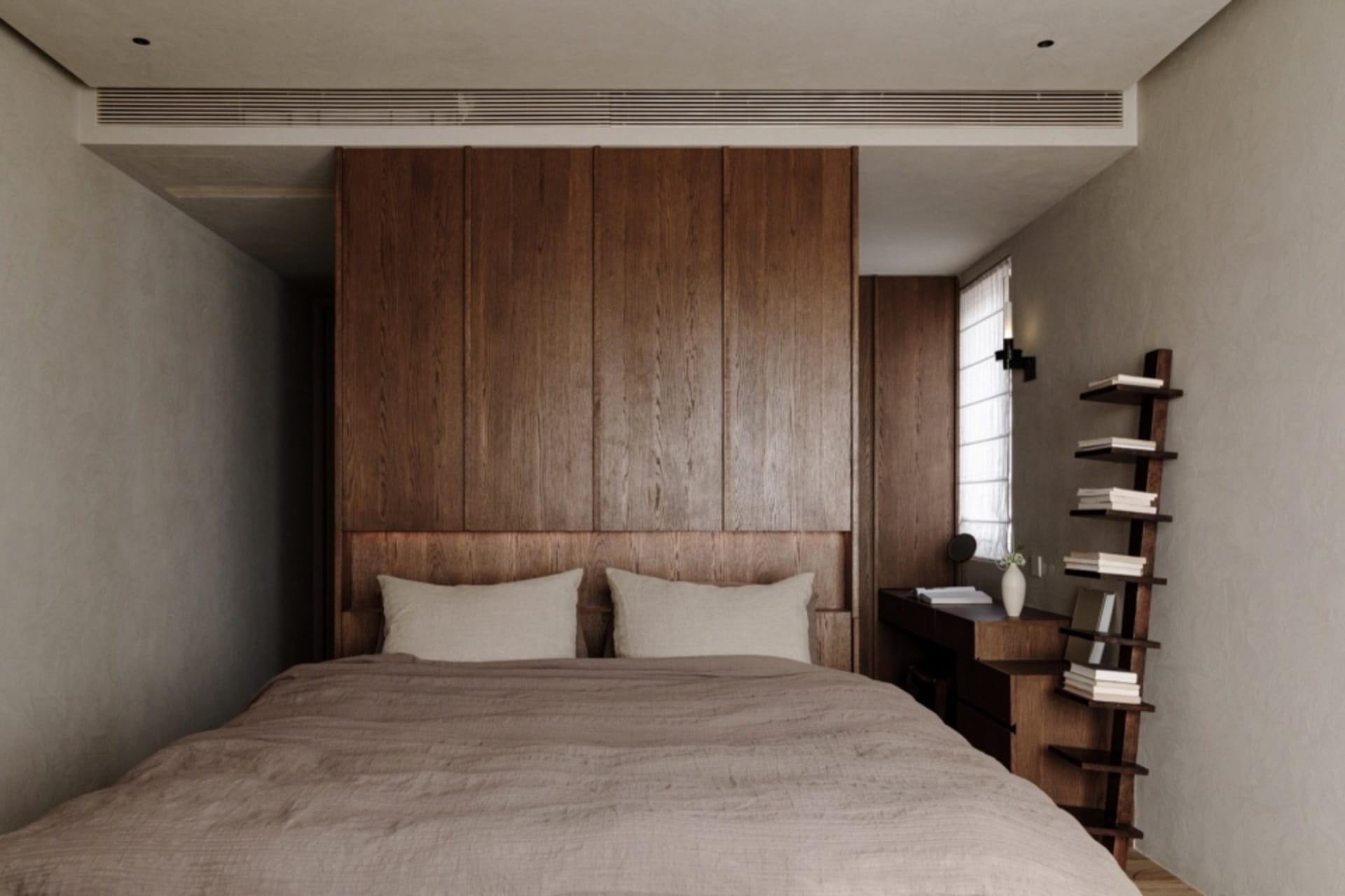 A serene minimalist bedroom featuring a bed with natural wooden headboard and a wooden bookshelf against the wall.