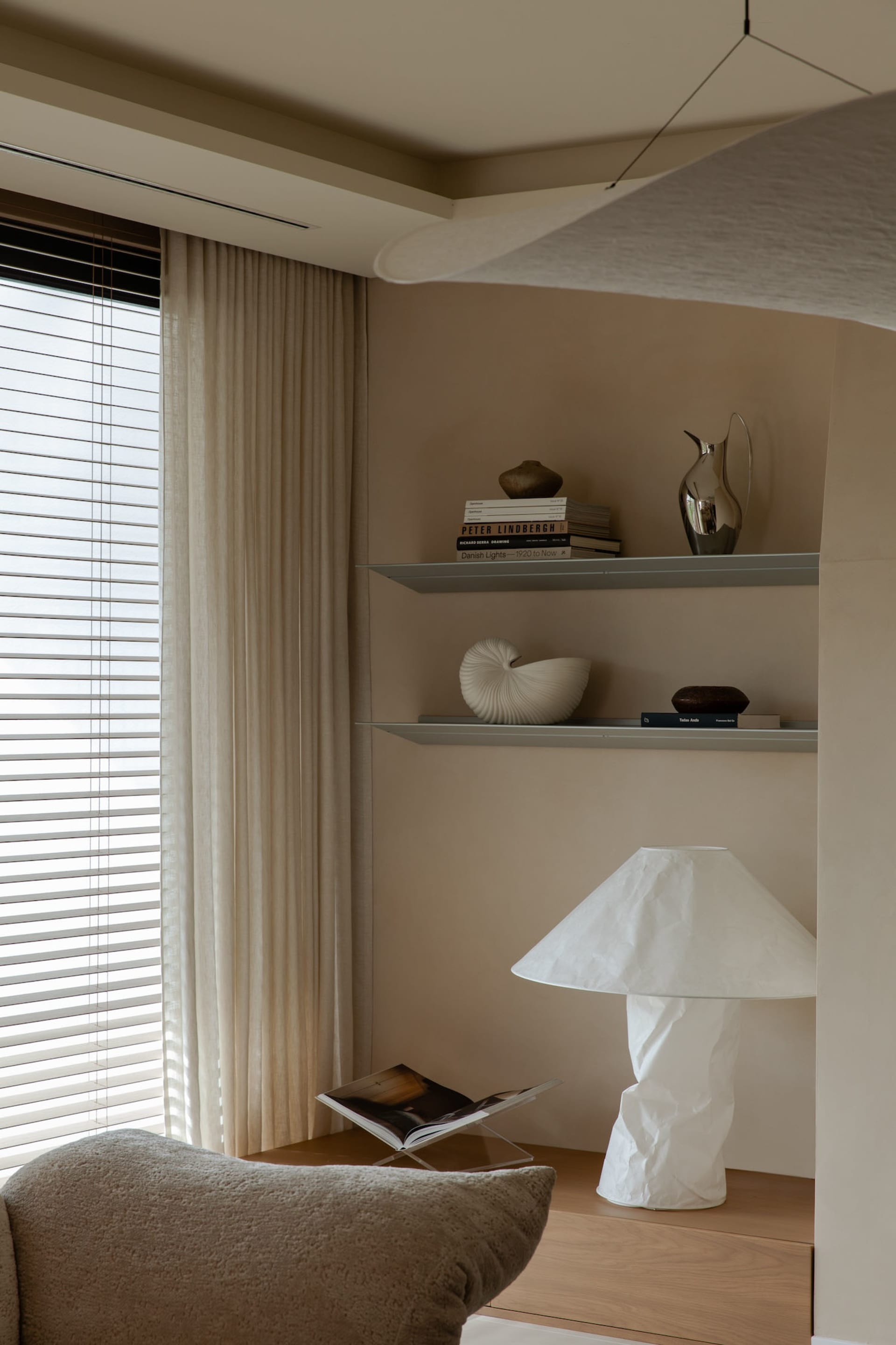 A modern, neutral-toned living room with a minimalist design.