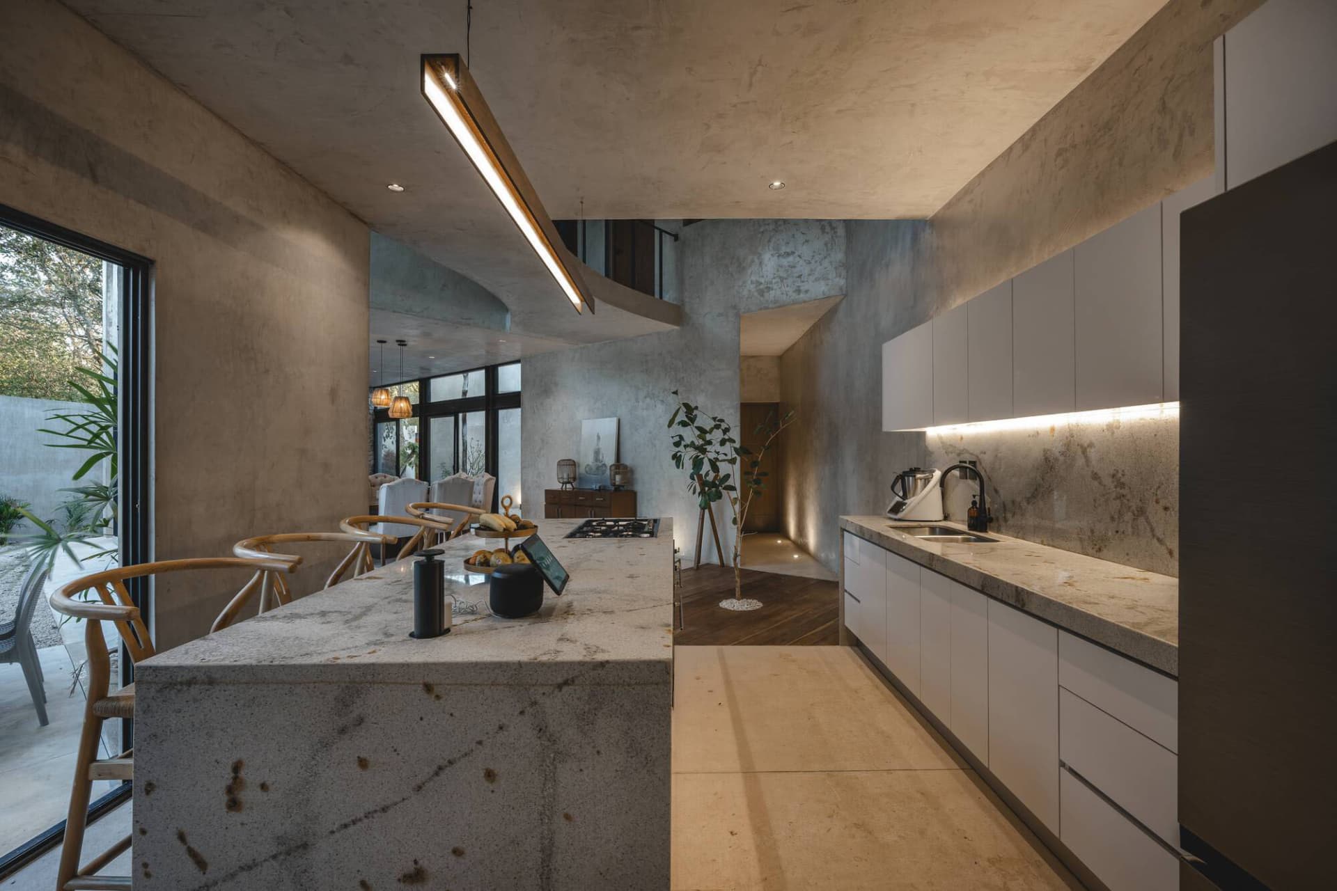 Modern industrial kitchen with concrete walls, stone counter, and minimalist design.