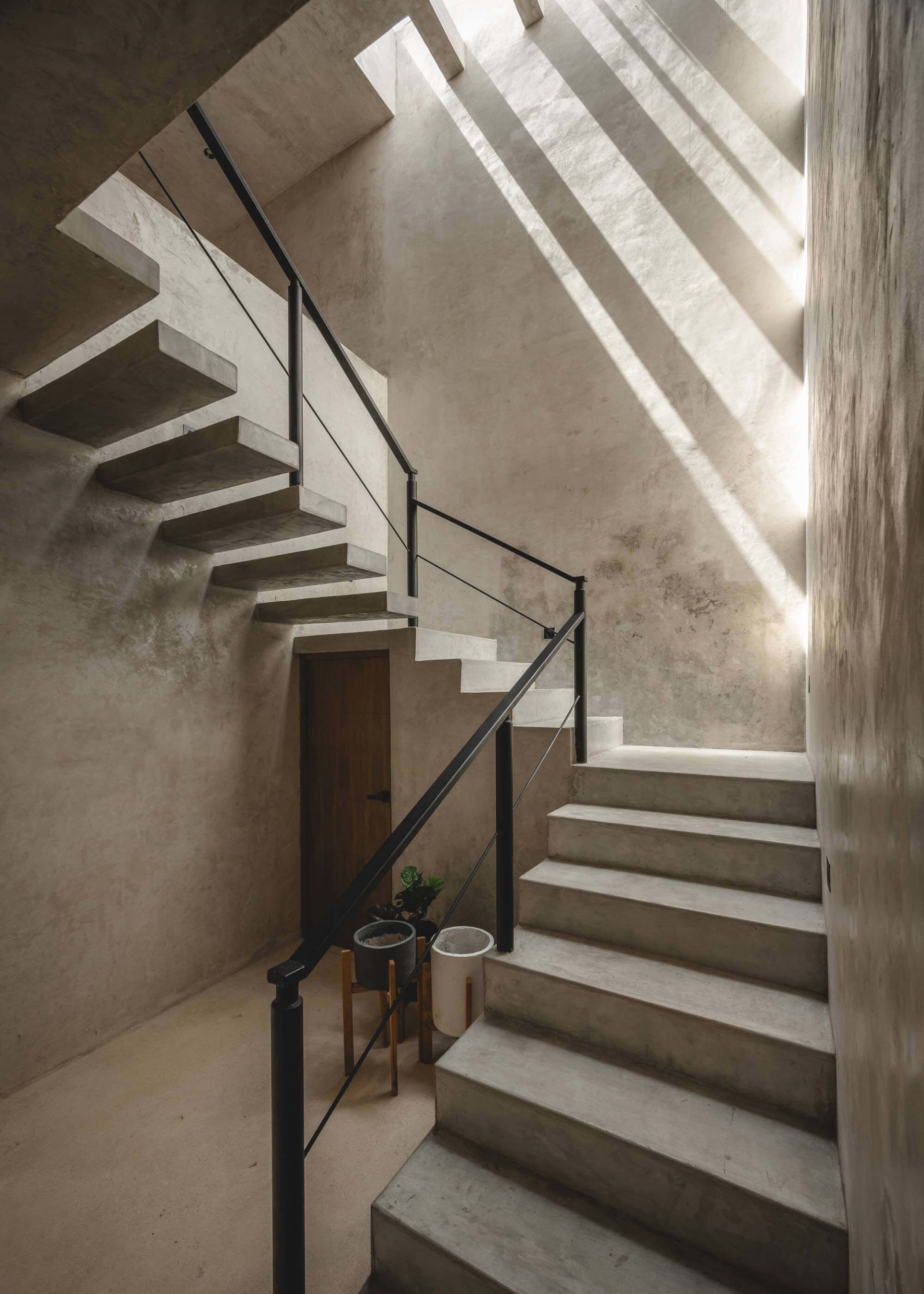 Minimalist interior with concrete staircase and skylight.