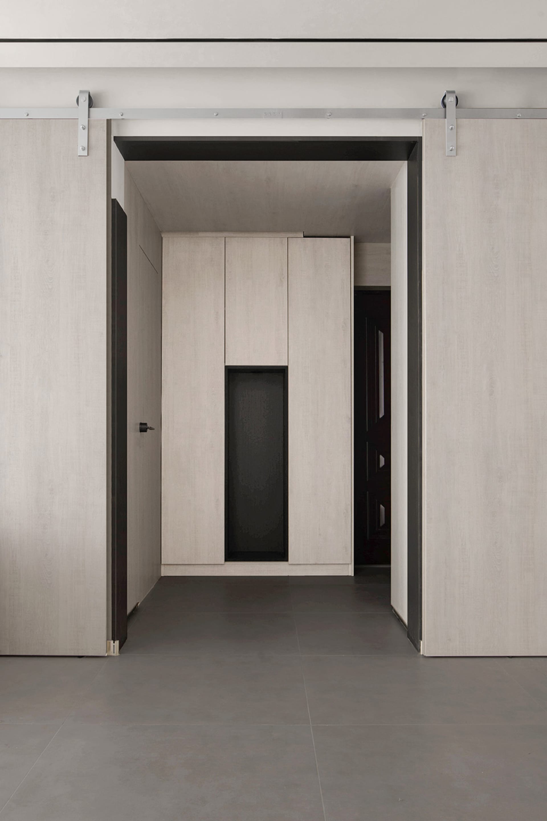 A modern minimalist bedroom featuring wooden cabinets and flooring.