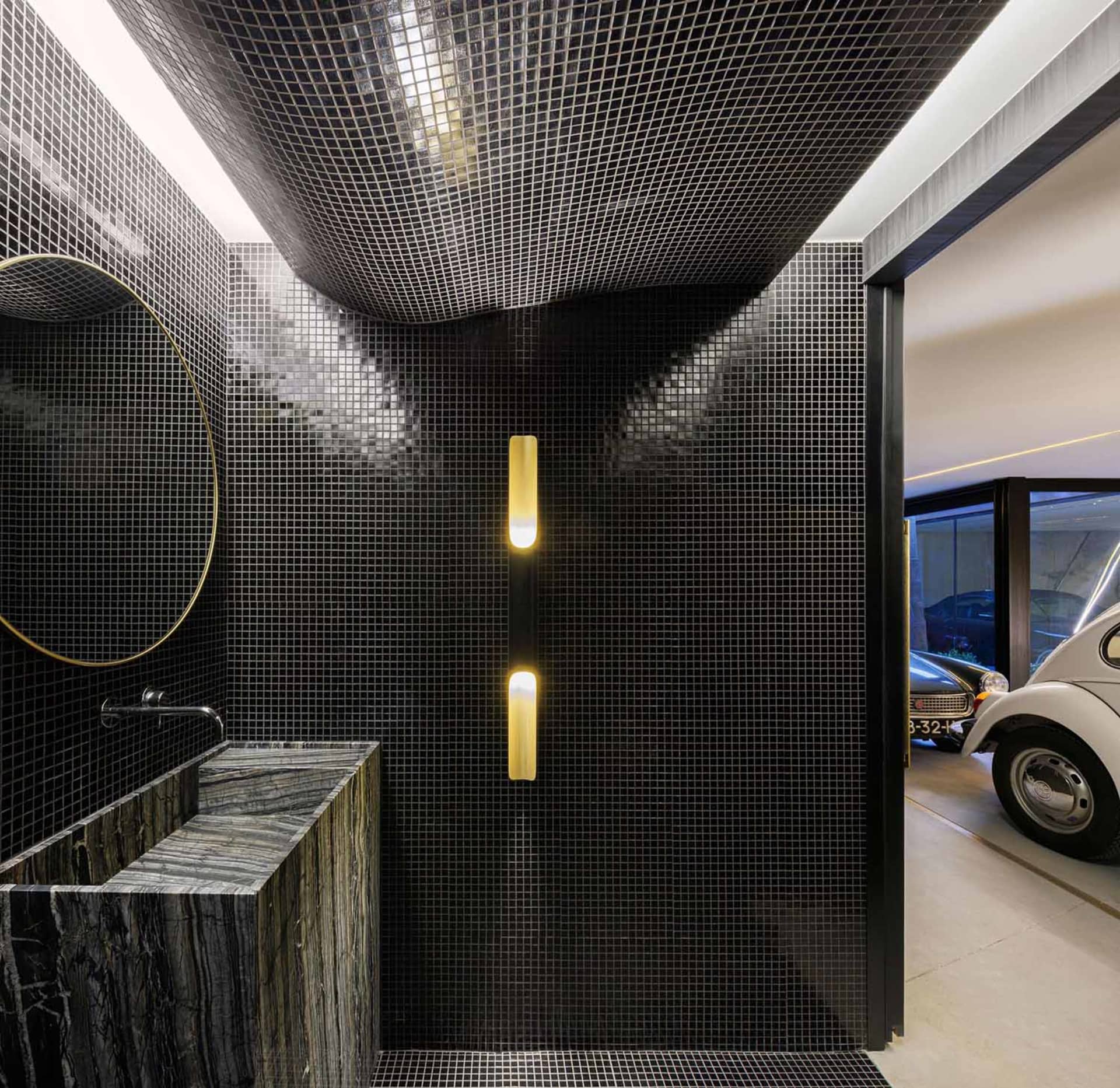 Modern bathroom with black metallic tiles and a minimalist design.