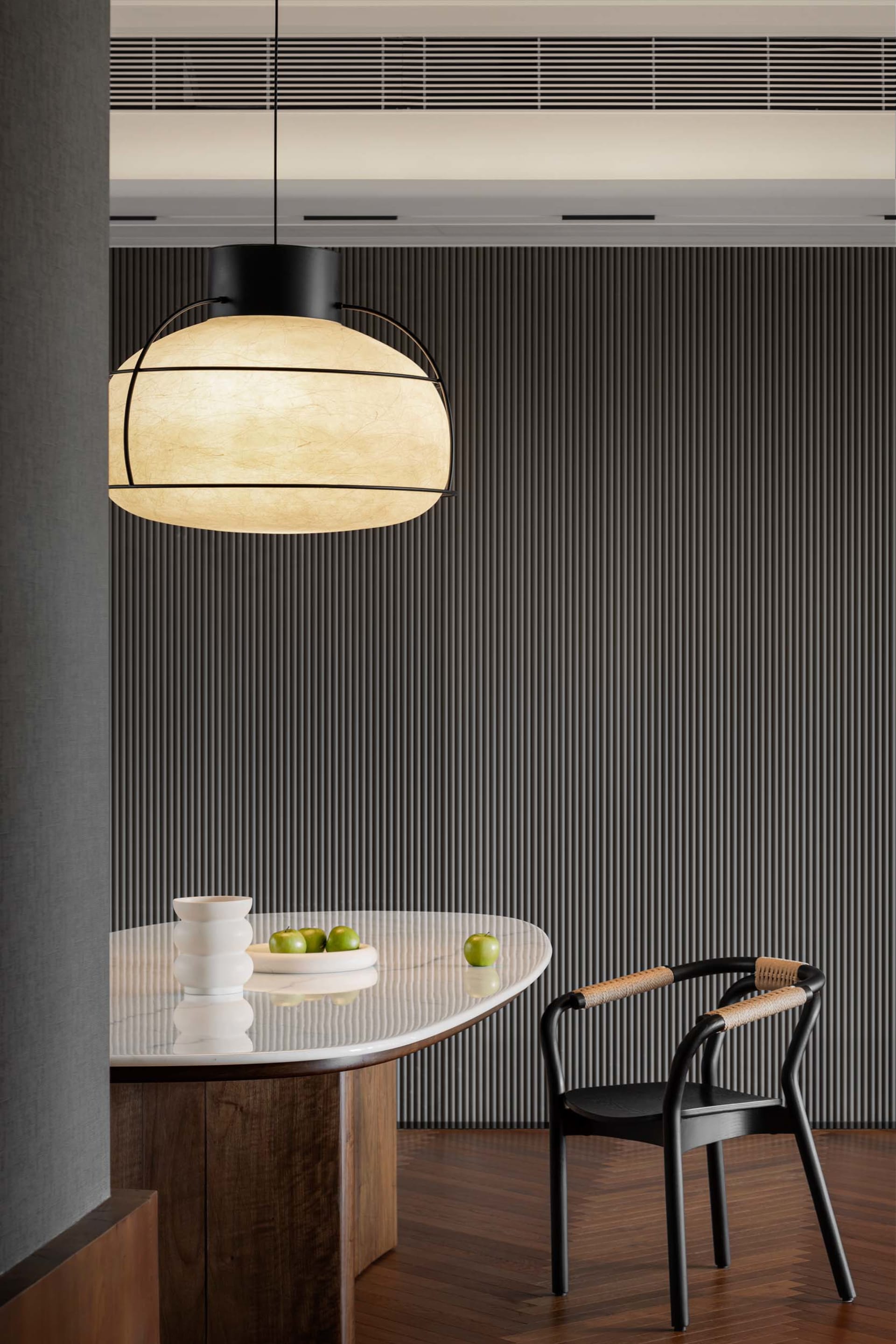 Modern dining area with marble table and minimalist chair.