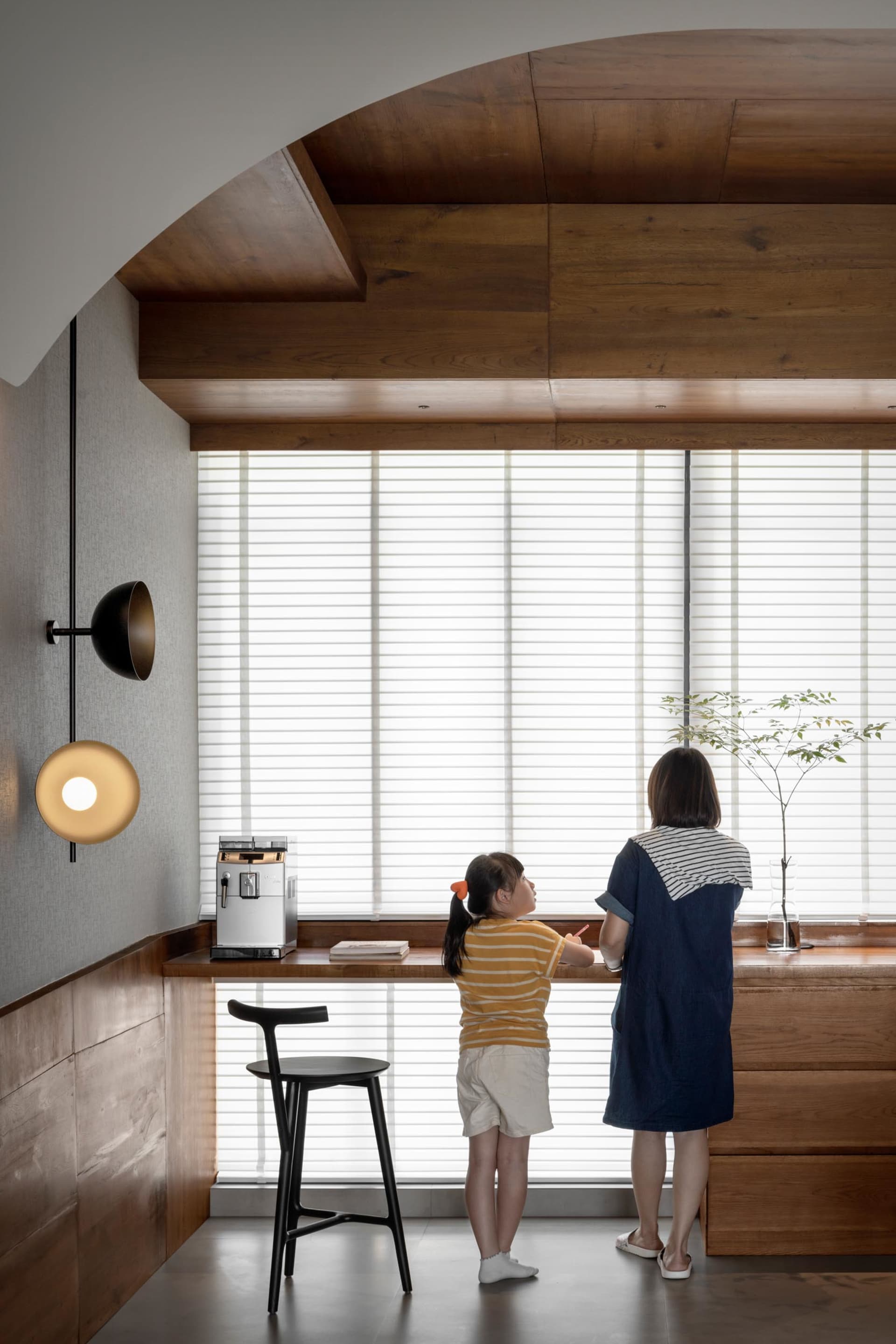 A modern family living space with wooden accents and a window with blinds.