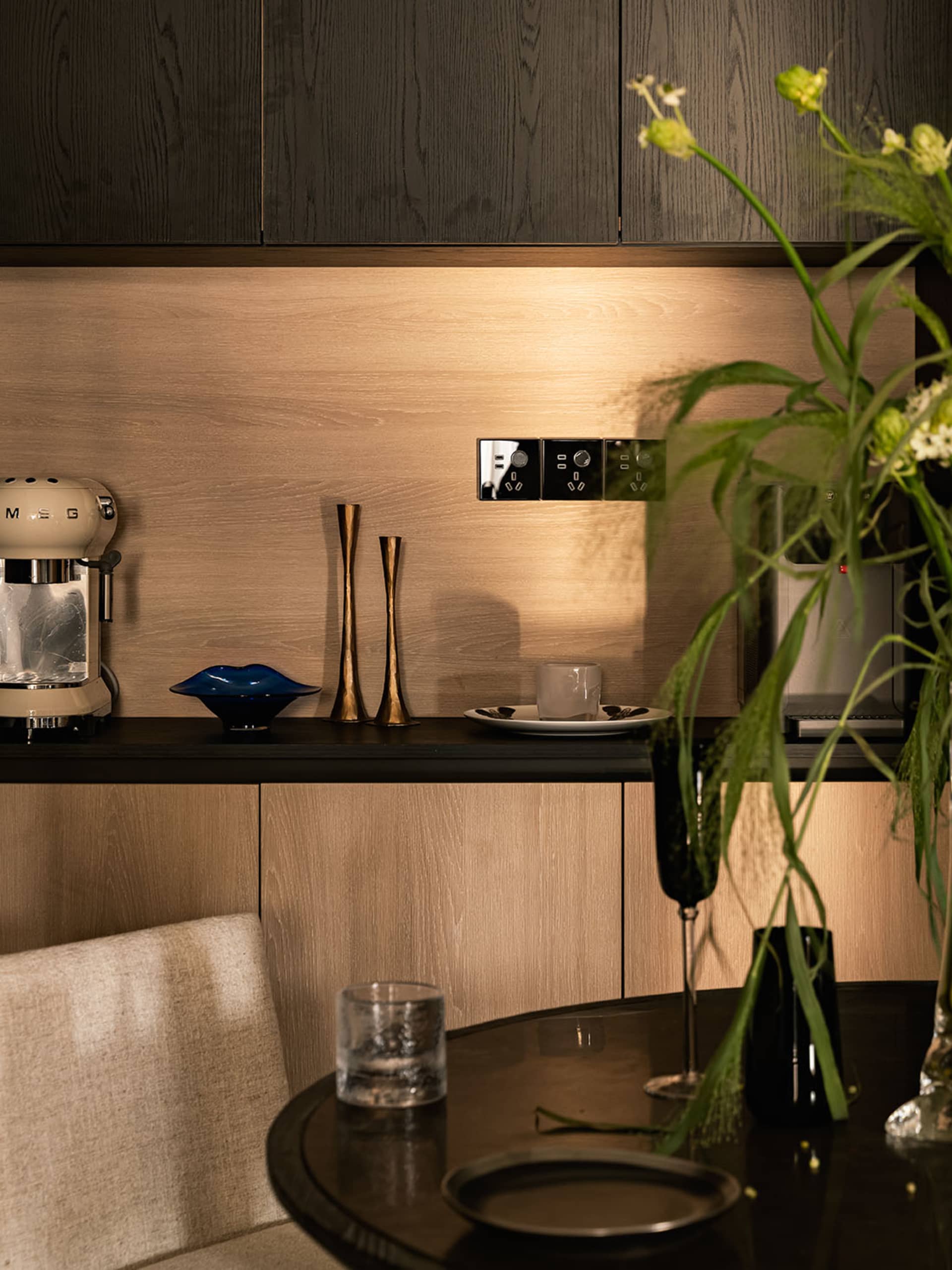 A minimalist residential kitchen featuring wooden cabinets with modern appliances and clean lines.