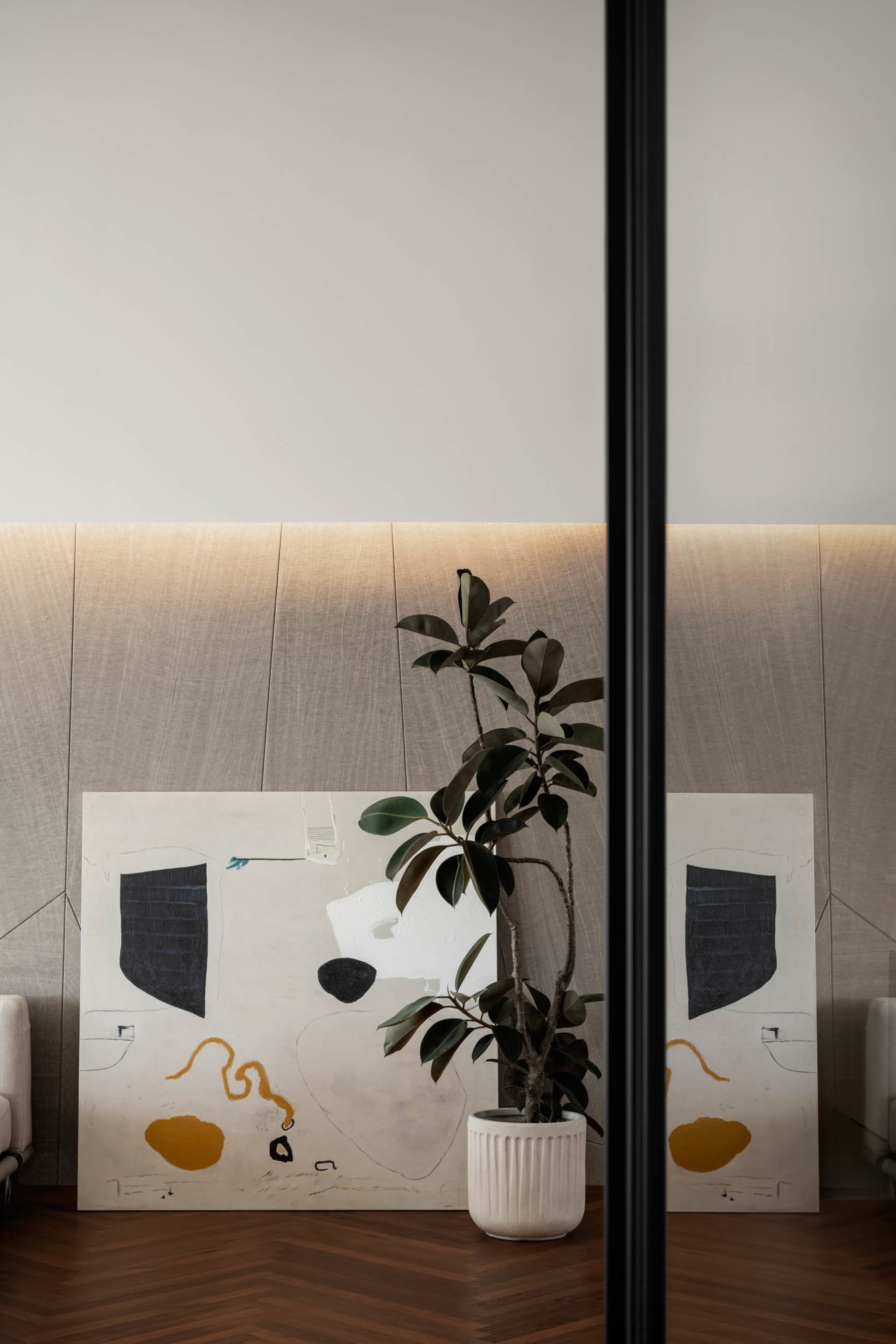 A modern minimalist interior design featuring abstract artwork with geometric shapes on a white, textured background, complem