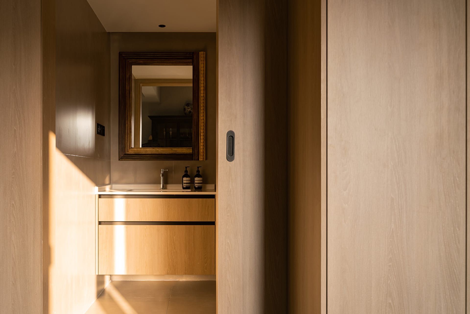 Minimalist bathroom featuring wooden fixtures and stone accents.