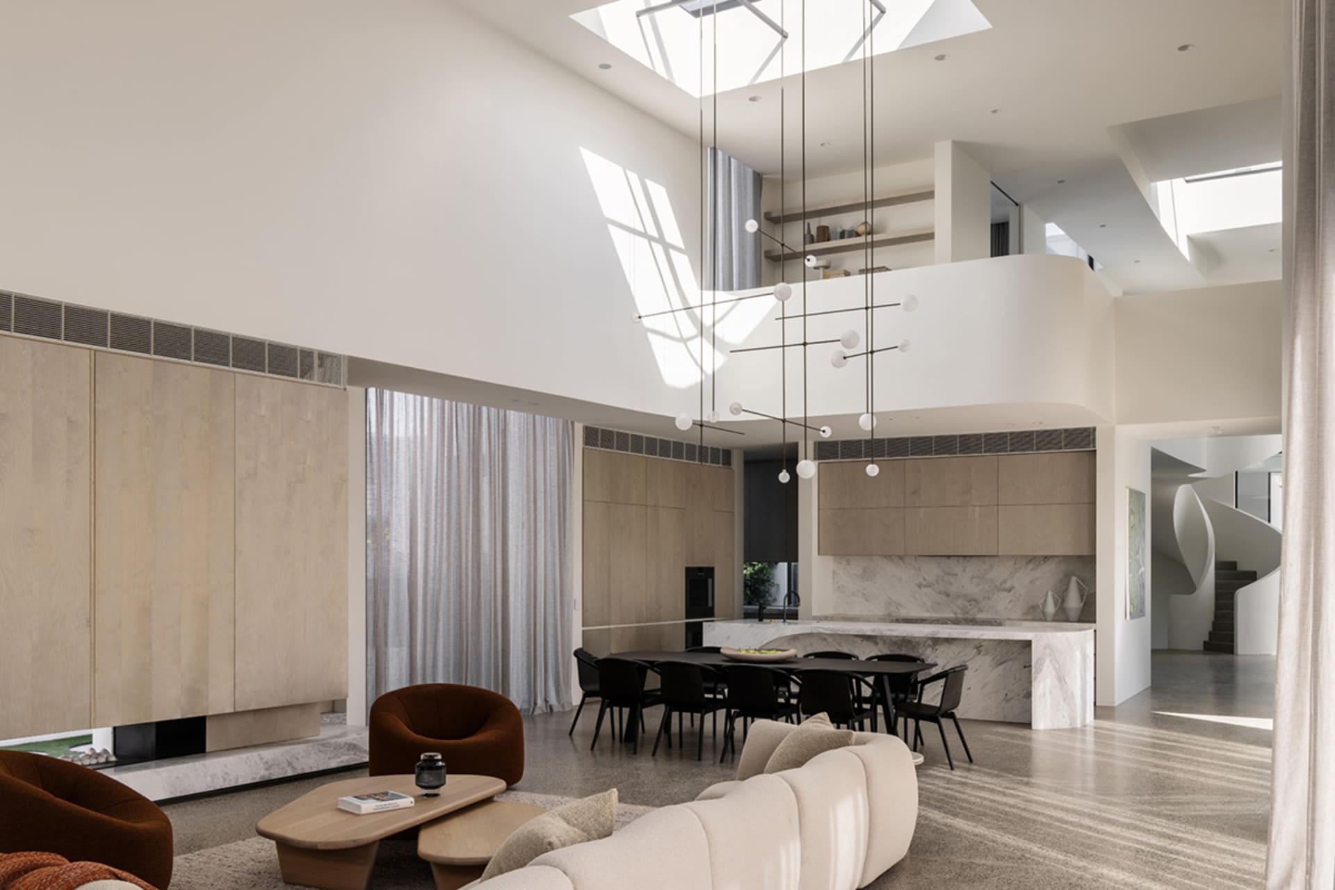 Modern open-plan living room featuring minimalist design, neutral color palette, and natural light