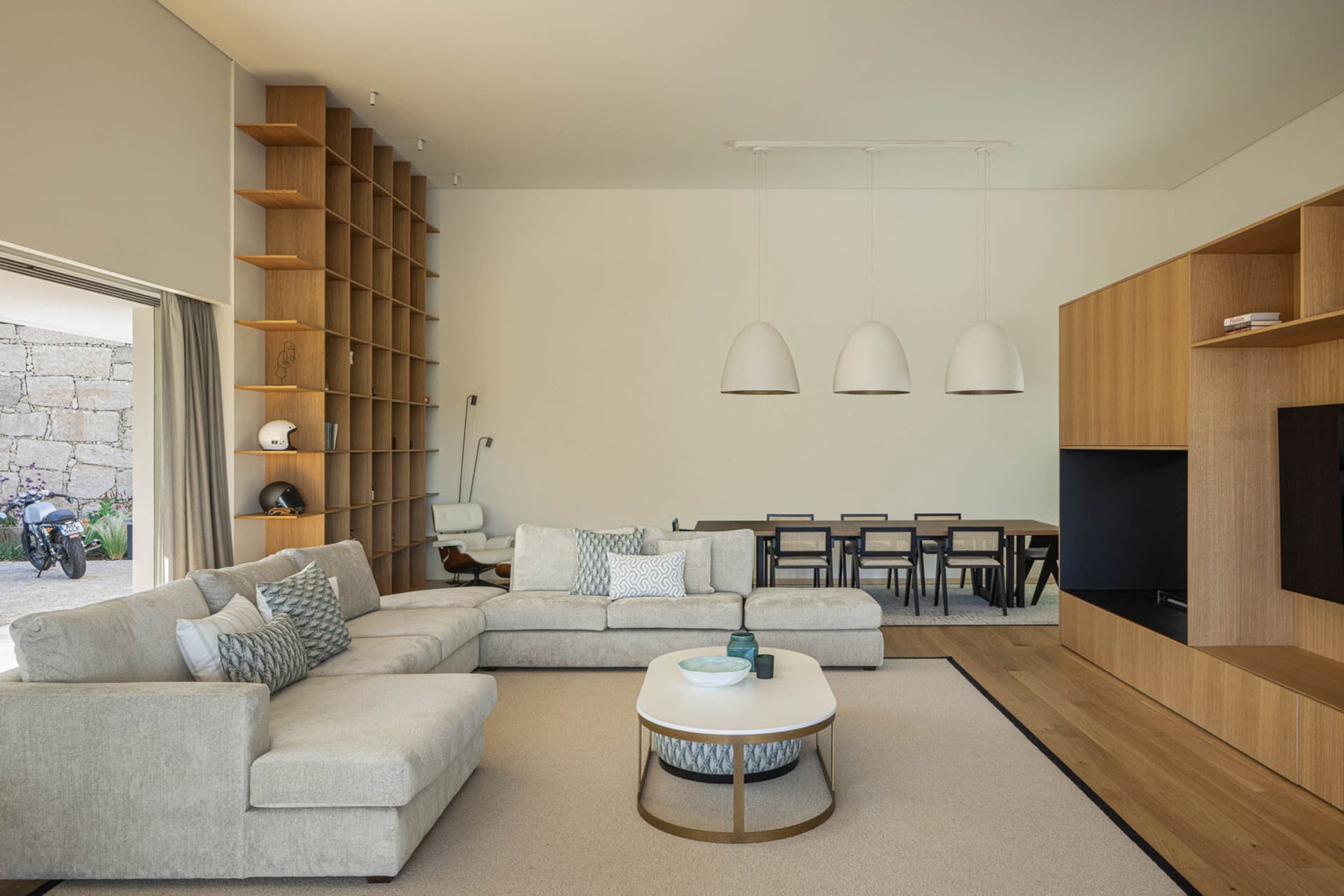 A modern living room featuring concrete and wood materials, with a steel coffee table and comfortable seating.