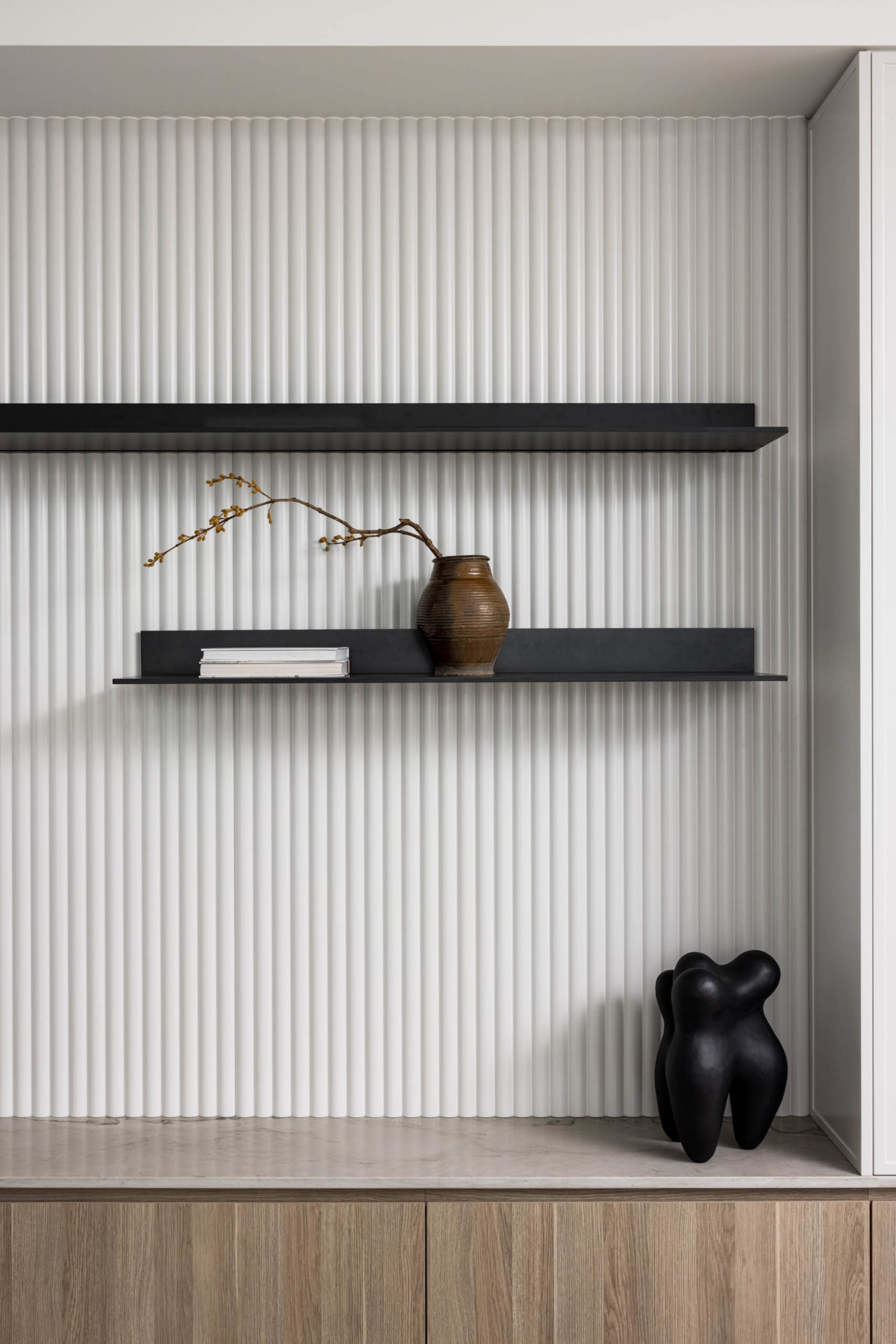 Modern shelves with metal shelves, a vase, a book, and a statue on a ribbed wall background.