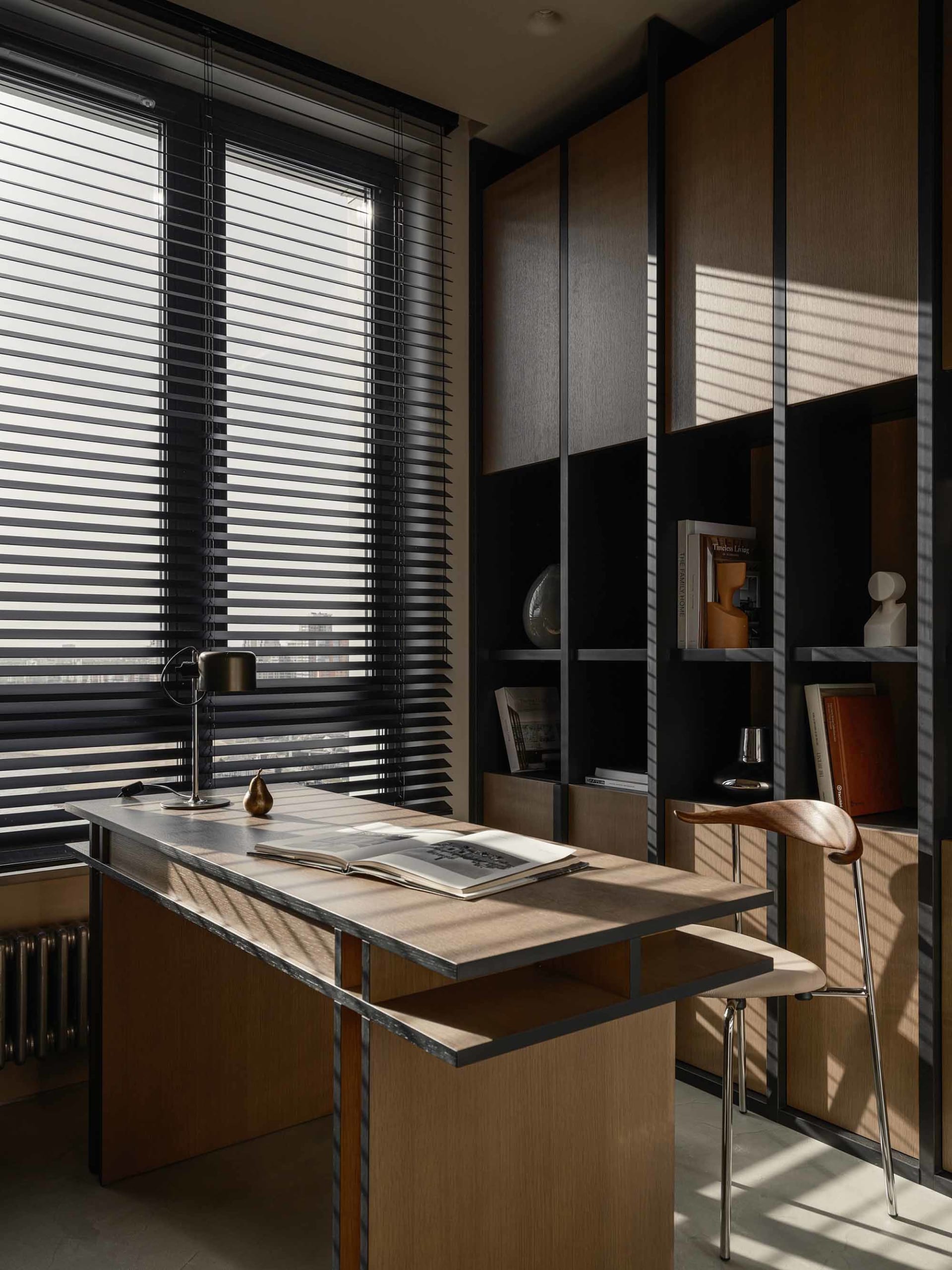 Modern home office with industrial design, featuring a wooden desk and bookshelf.