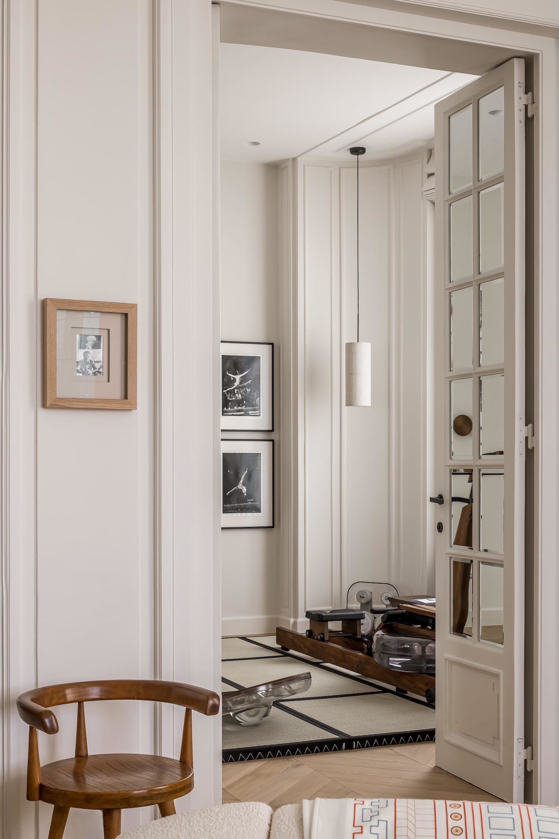 A modern home office featuring wooden shelves with glass and metal elements.