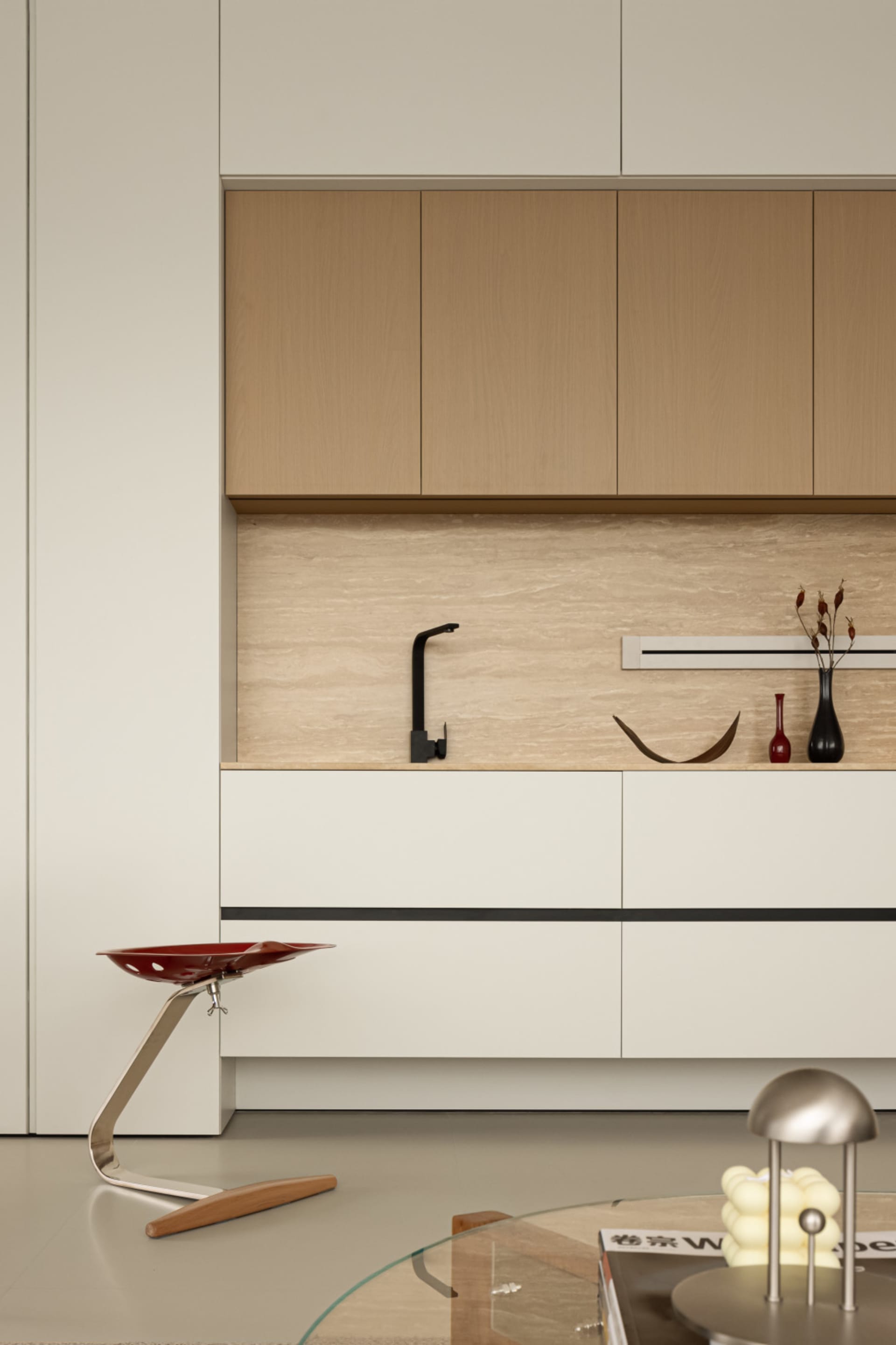 A modern, minimalist kitchen featuring wooden cabinets and marble countertops.