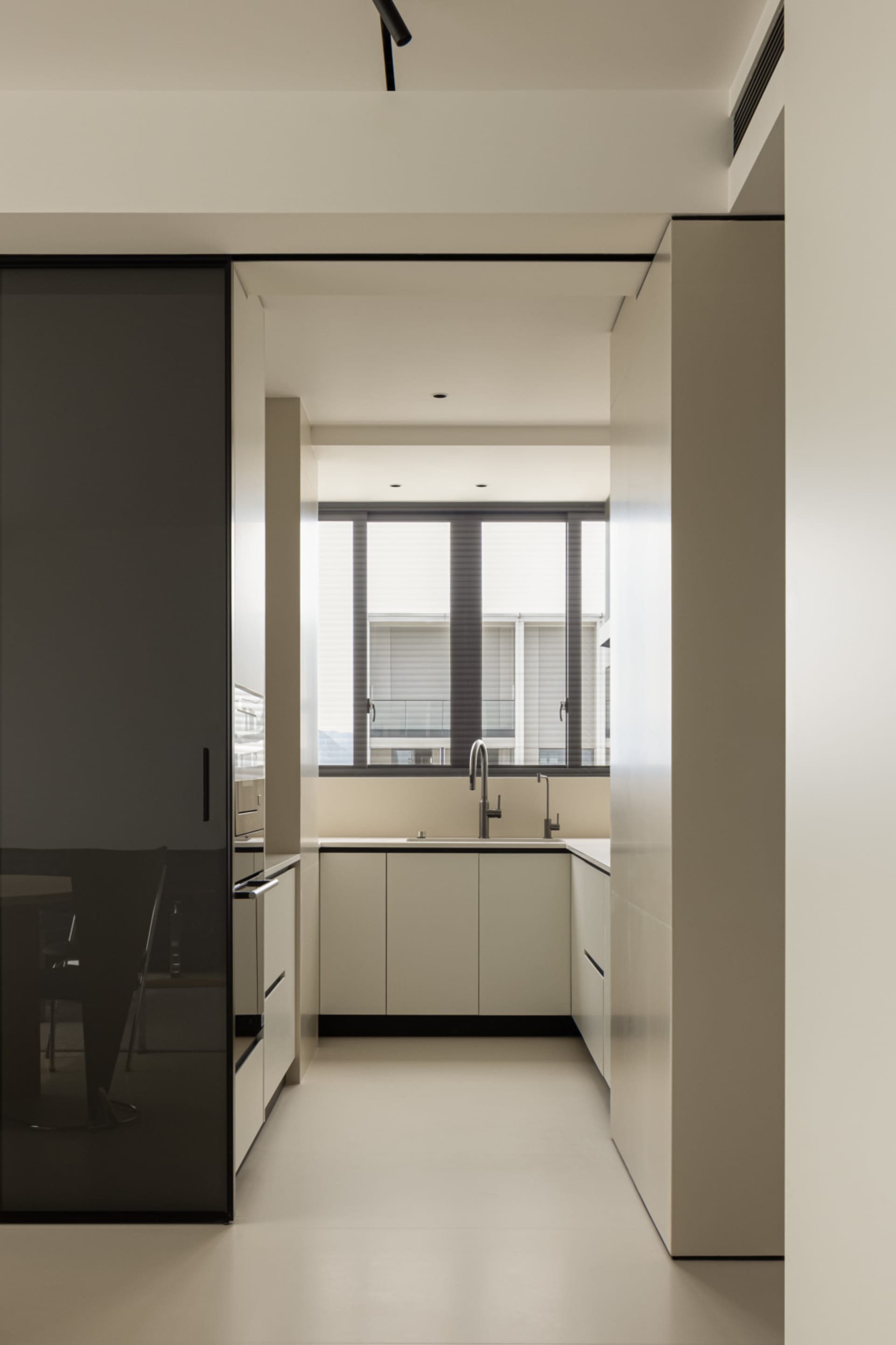 Modern minimalist kitchen with white cabinets and sleek design.