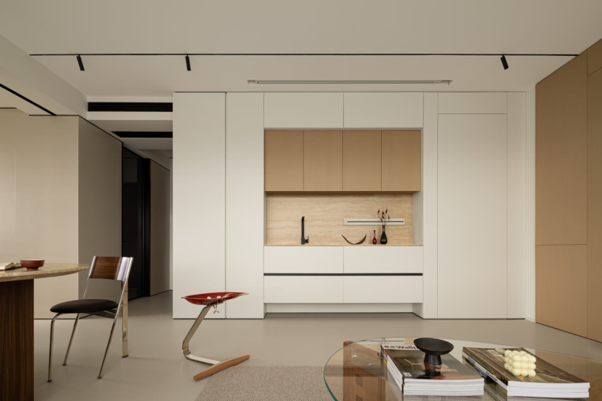 A minimalist kitchen featuring wood and white cabinets and countertops.