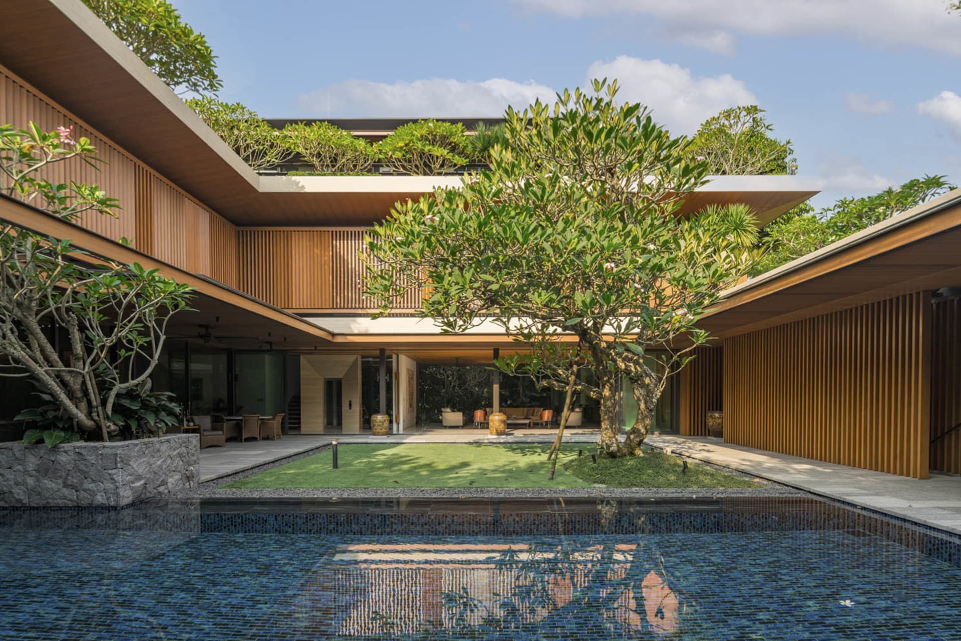 Contemporary residential house with wooden exterior and lush greenery.