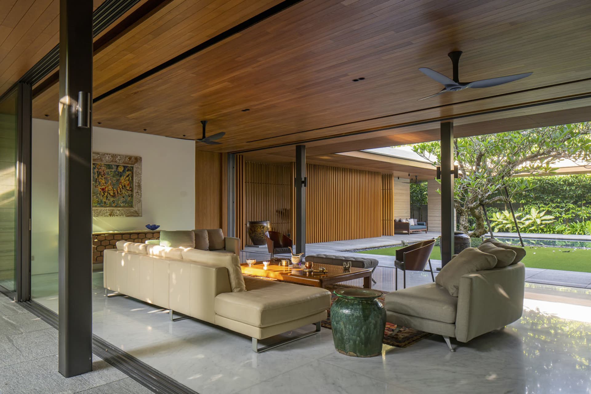 A modern living room with wooden elements and a large window overlooking a green outdoor space.