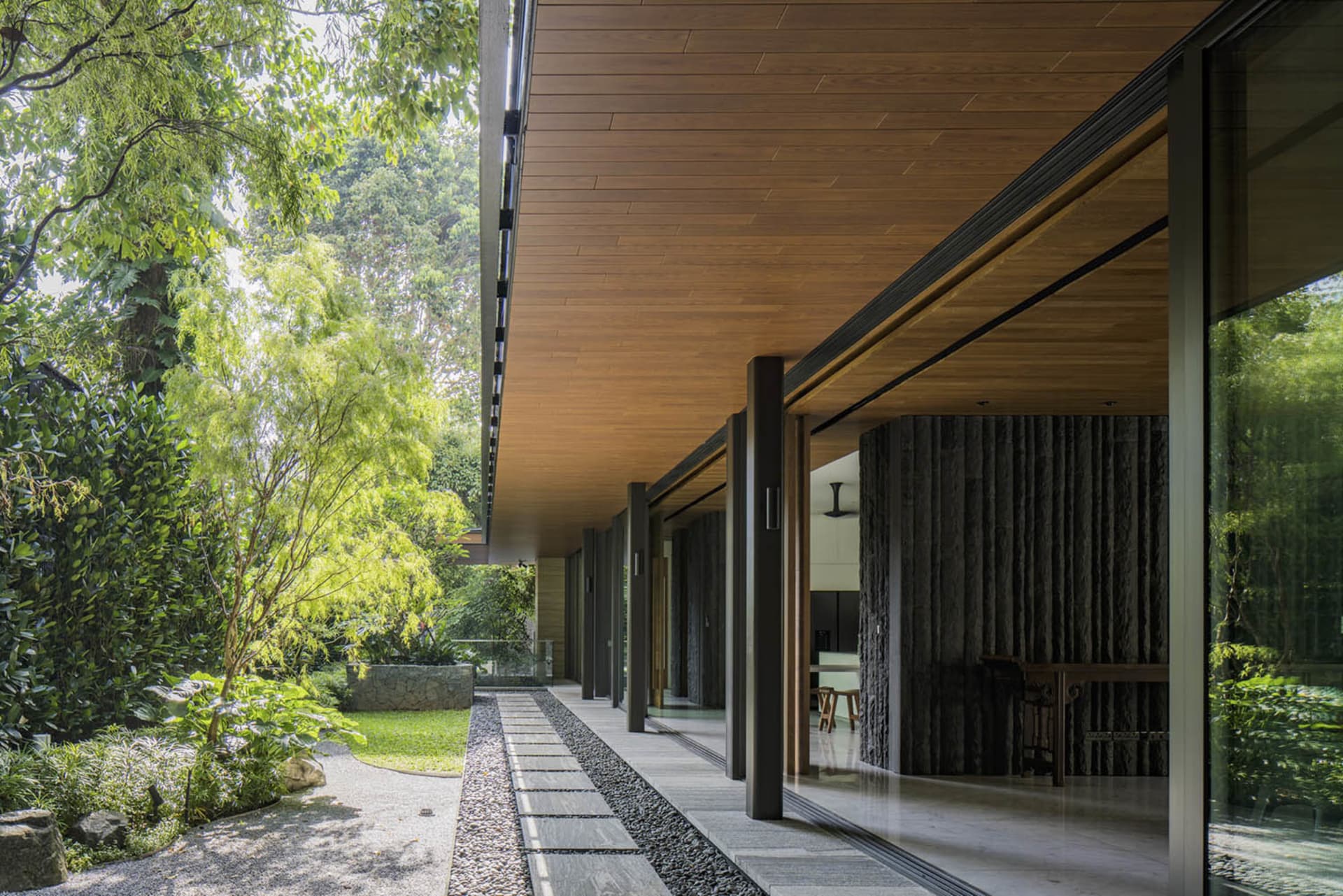 Modern home entrance featuring glass doors and a wooden ceiling